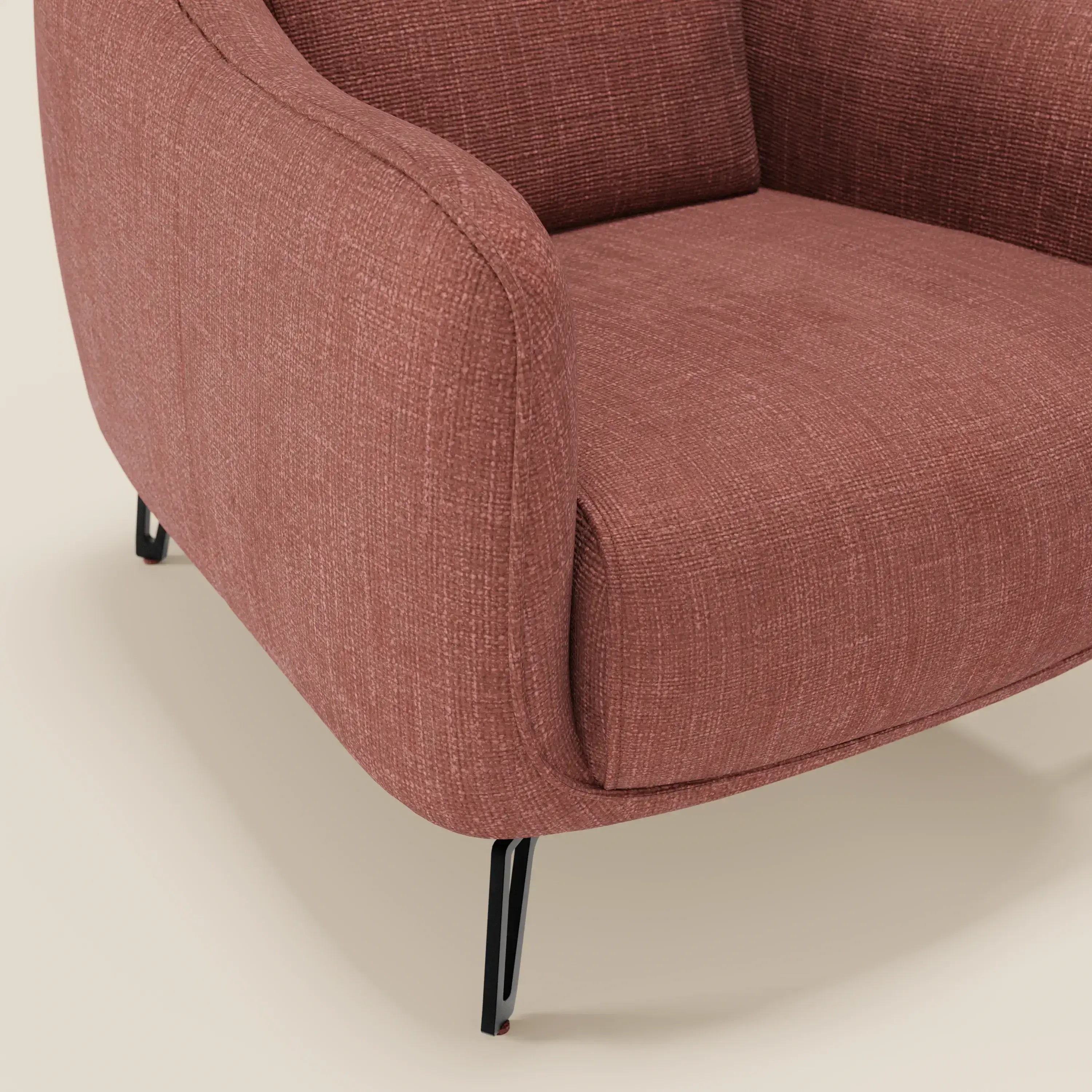 Avela Poltroncina di Divani.Store: comfort senza tempo in morbido tessuto impermeabile T06 corallo e gambe in metallo nero, design moderno dai bordi arrotondati su sfondo beige chiaro.