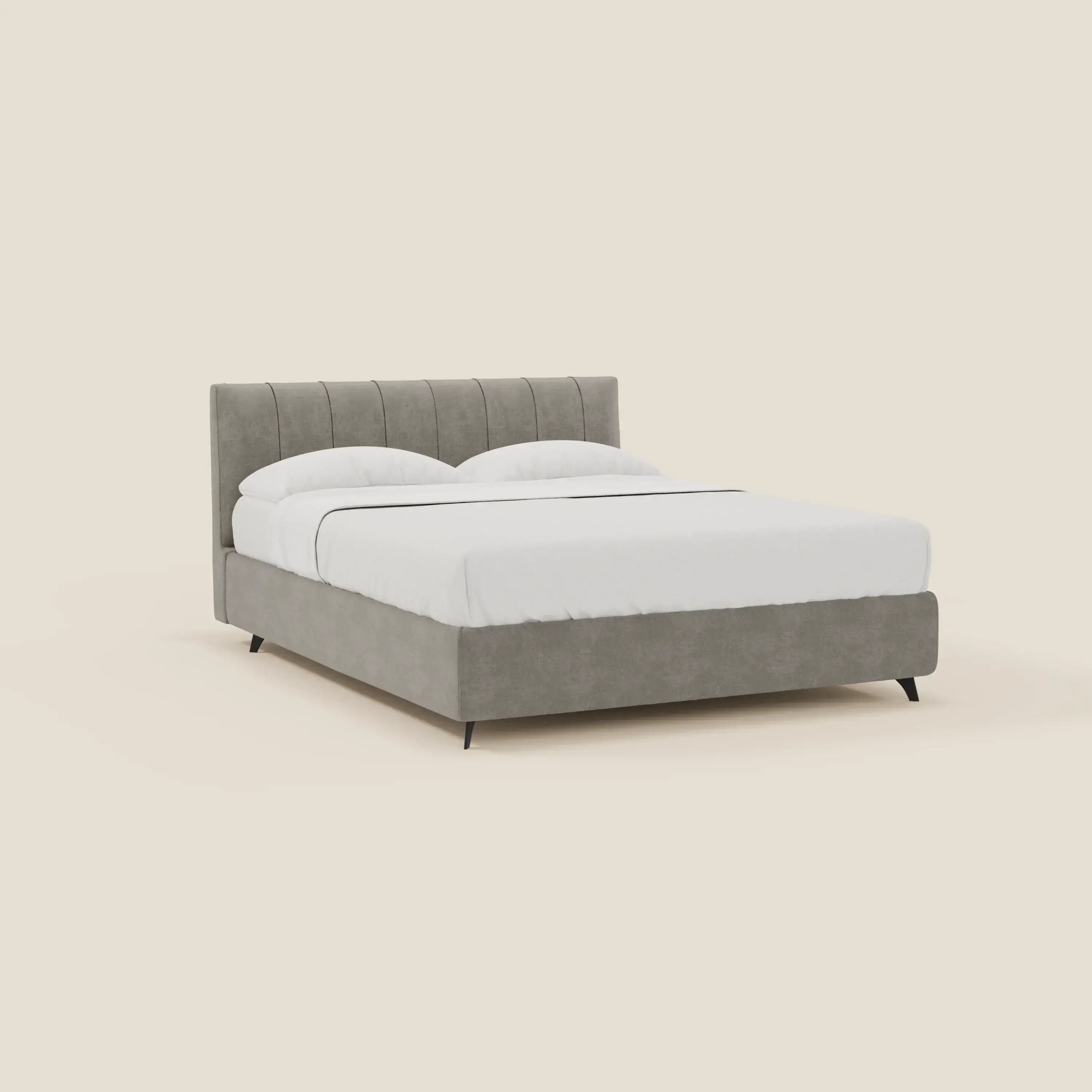 Il letto contenitore Bogart Edizione Grande Fratello di Letti.store è caratterizzato da un tessuto grigio chiaro T22 sfoderabile e antimacchia e da una testiera con piedini verticali, presentata con una biancheria da letto bianca su un semplice sfondo beige per un look elegante e moderno.