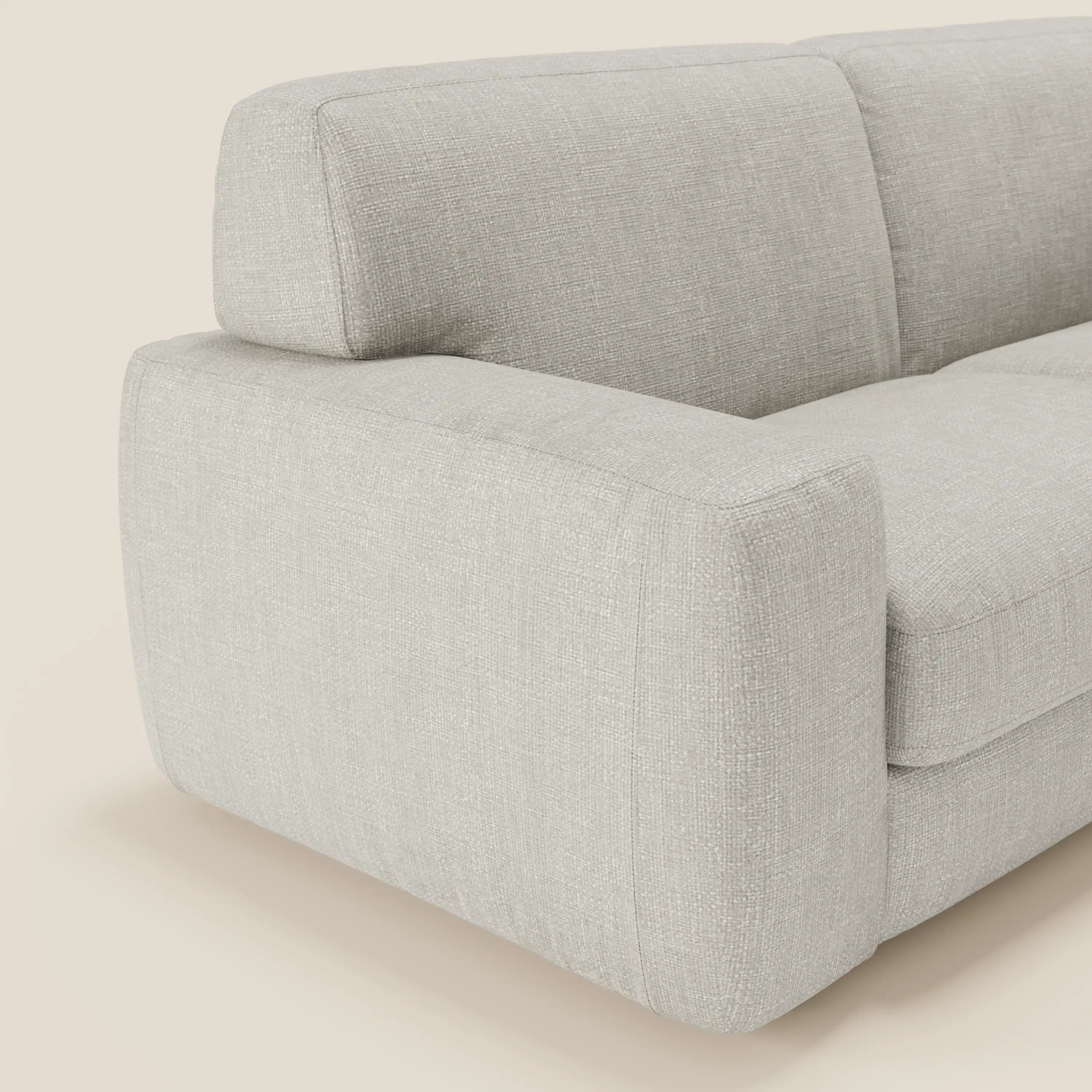 Primo piano del letto materasso Cloud Divano H17 cm di Divani.Store, caratterizzato da morbidi cuscini in tessuto impermeabile T06 grigio chiaro, ampi braccioli e schienale morbido: le sue linee compatte e minimaliste offrono un comfort quotidiano su uno sfondo chiaro.