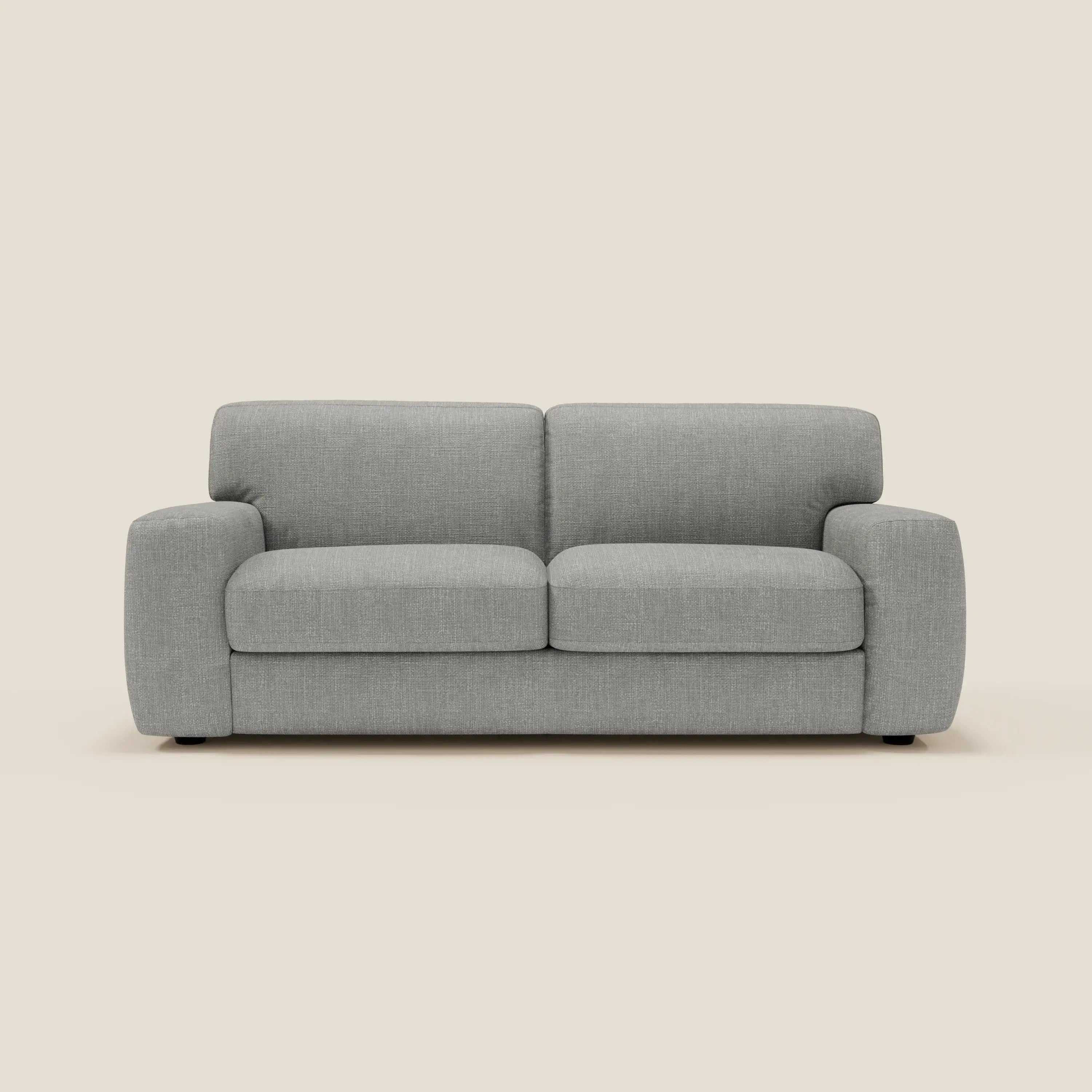 Un moderno Divani.Store Cloud Divano letto in tessuto impermeabile T06 grigio chiaro, con cuscini in feltro e braccioli arrotondati, si staglia su uno sfondo color crema. Questo divano minimalista a due o tre posti è caratterizzato da discrete gambe nere.