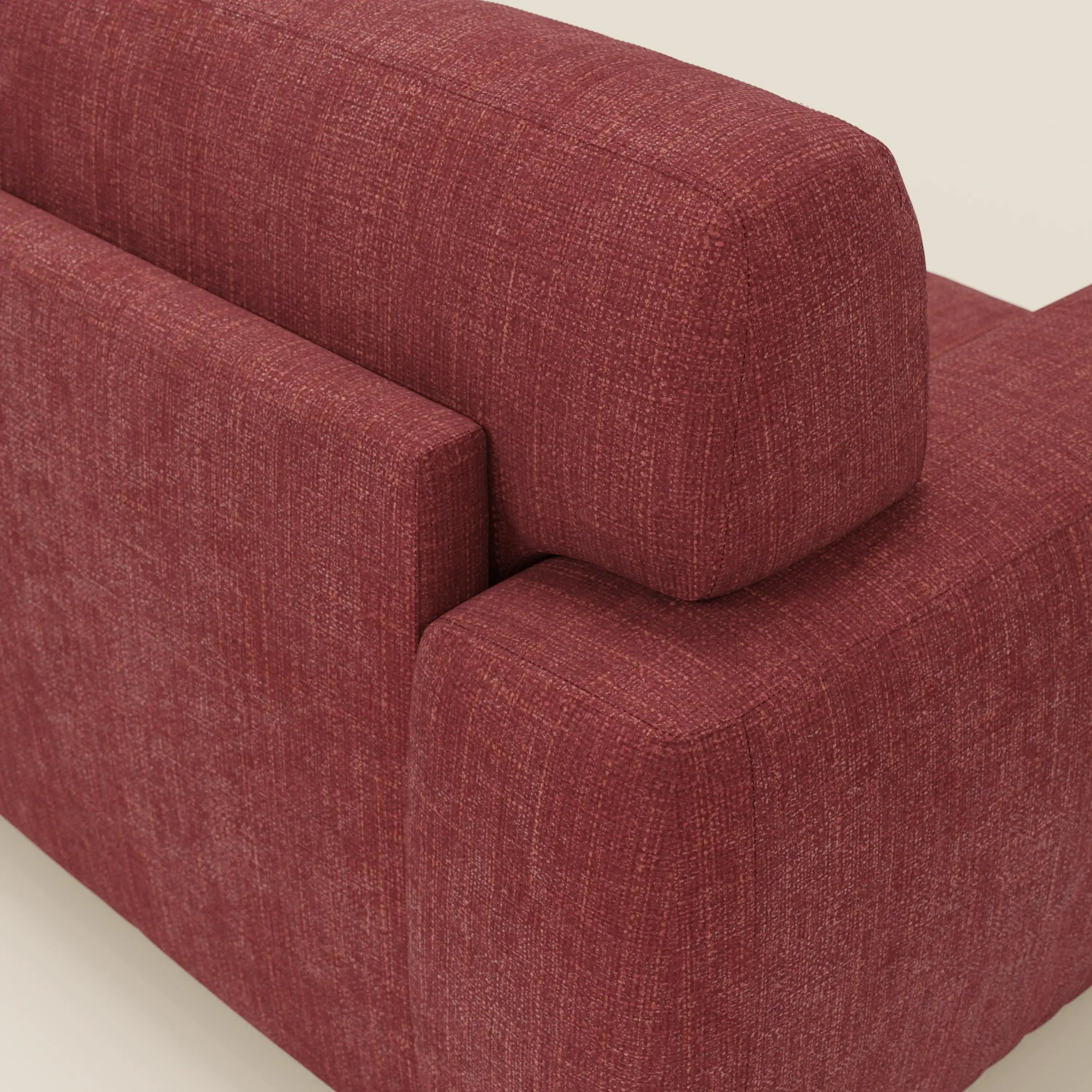 Primo piano dello schienale e del bracciolo di Cloud Divano letto materasso H17 cm di Divani.Store in tessuto impermeabile T06 rosso, che mette in evidenza le linee pulite, i bordi squadrati e i morbidi cuscini su uno sfondo beige neutro.