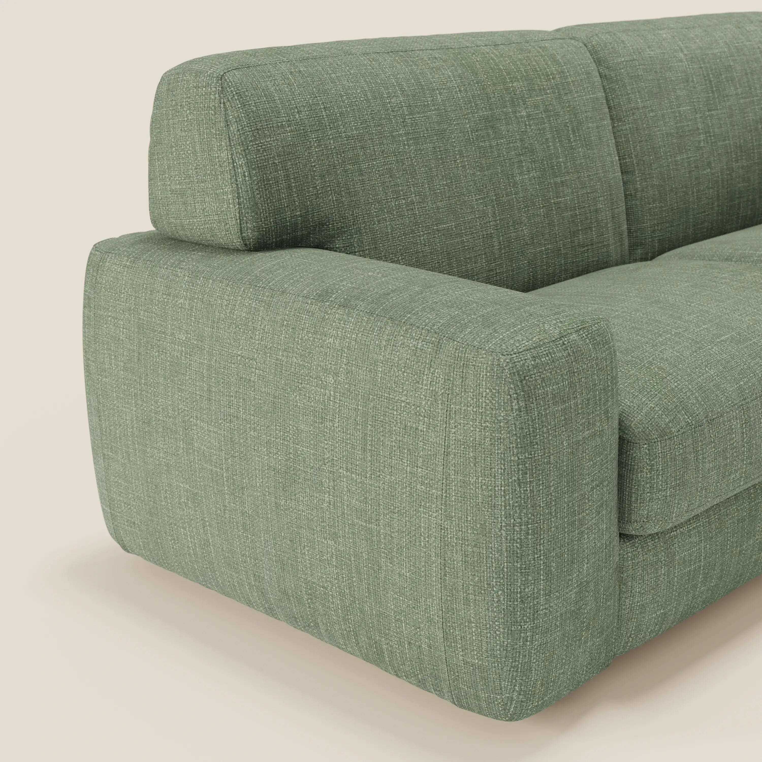 Primo piano del divano letto materasso Cloud H17 cm di Divani.Store, caratterizzato da morbidi cuscini in tessuto impermeabile T06 verde, che mette in evidenza il bracciolo sinistro, il cuscino di seduta e lo schienale su uno sfondo bianco pieno.
