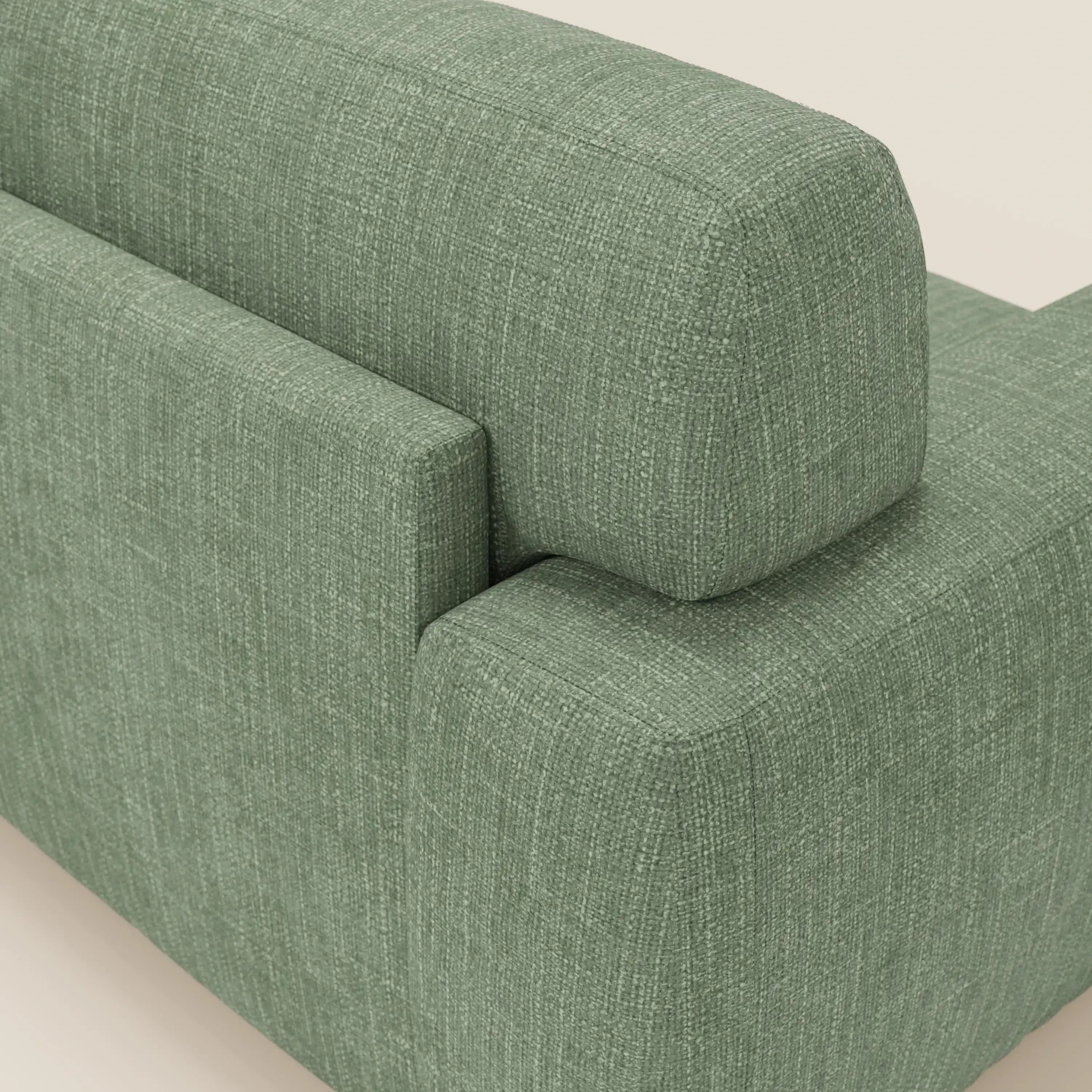 Primo piano del divano letto materasso Cloud di Divani.Store, H17 cm, con morbidi cuscini in tessuto impermeabile verde T06. Il design moderno e squadrato è caratterizzato da linee pulite e da un'imbottitura a trama intrecciata su uno sfondo bianco sporco.