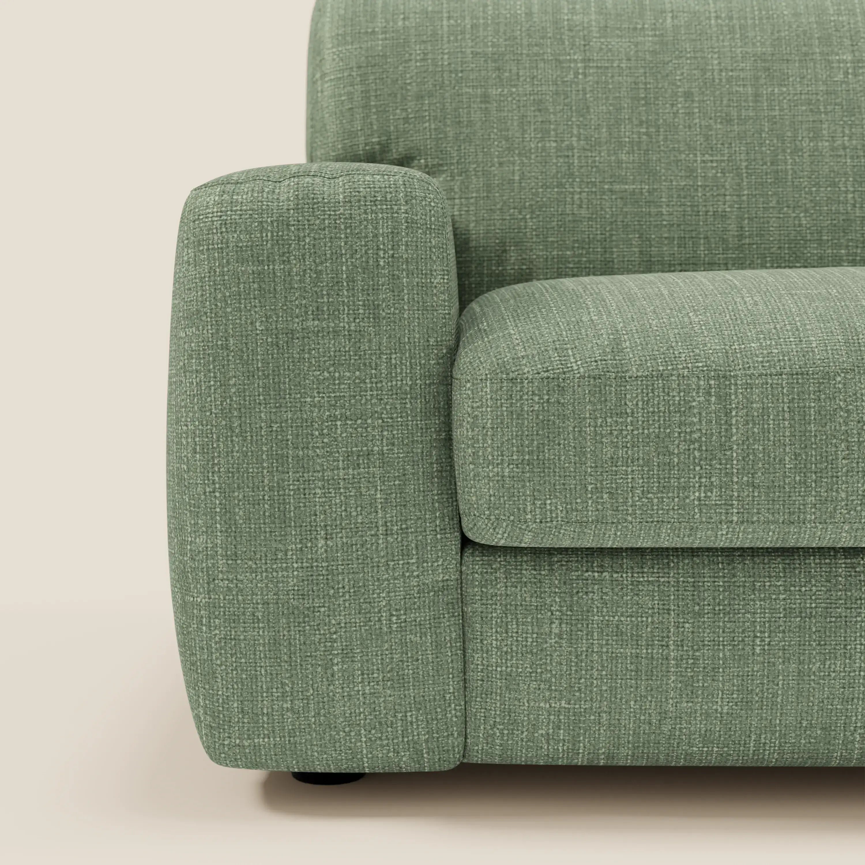 Primo piano del lato sinistro del letto materasso Cloud Divano H17 cm di Divani.Store, caratterizzato da morbidi cuscini in tessuto impermeabile verde T06. Il bracciolo, la seduta e lo schienale evidenziano il comfort quotidiano su uno sfondo beige chiaro.