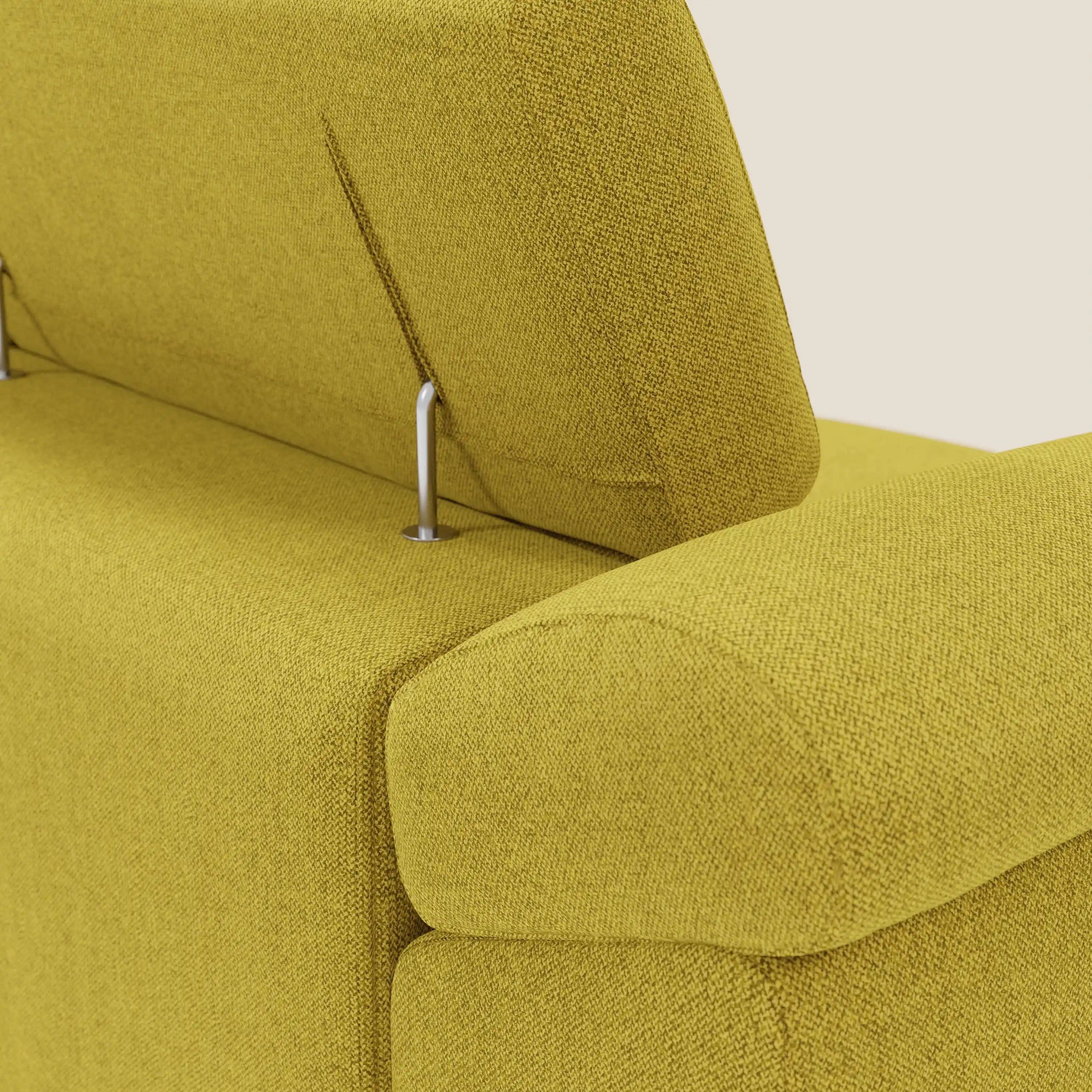 Primo piano del divano Donatello di Divani.Store in tessuto T23 giallo sole, con 3 sedute allungabili, supporto dello schienale in metallo, ampio bracciolo imbottito con contenitore e poggiatesta regolabile su uno sfondo beige chiaro.