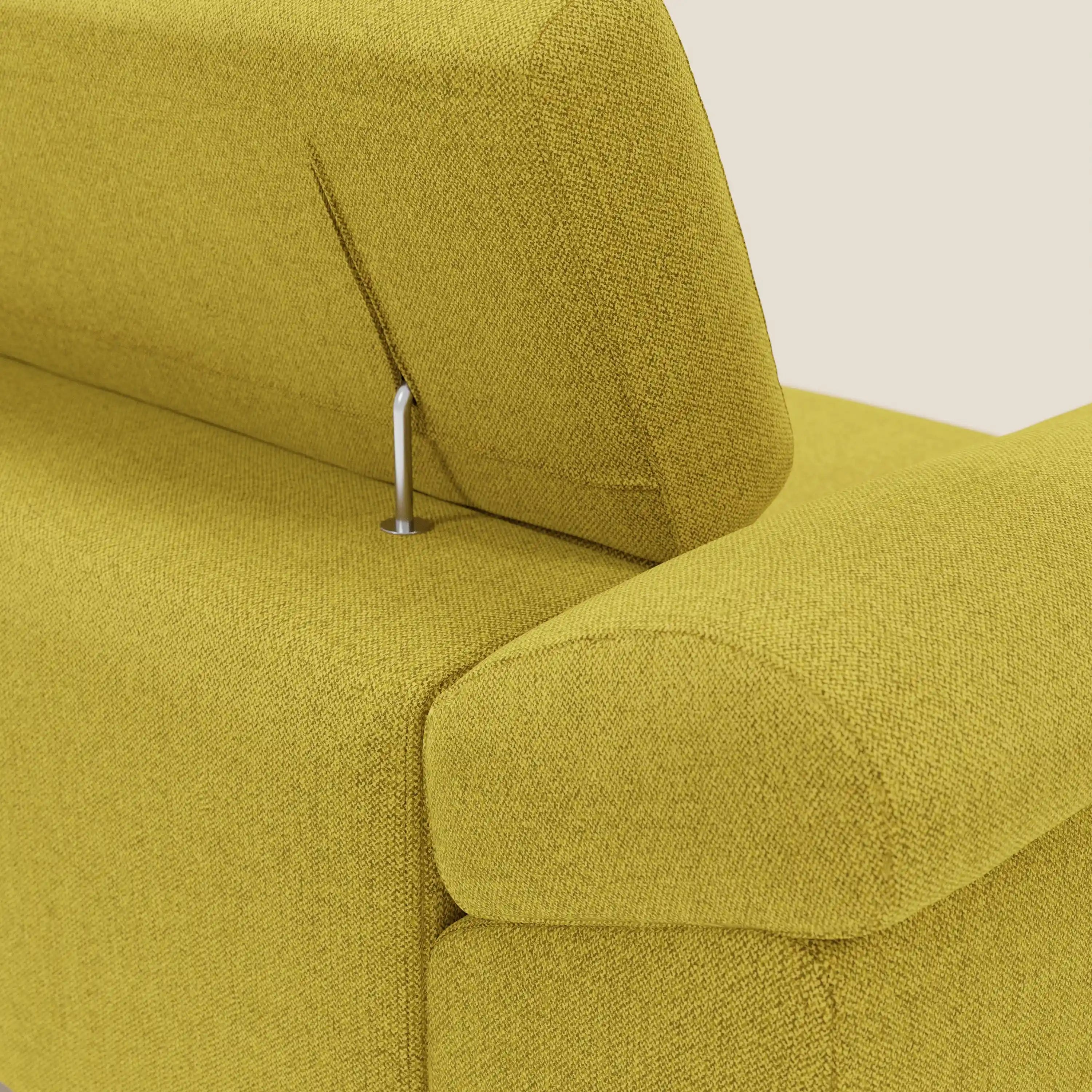 Primo piano del divano Donatello di Divani.Store in tessuto antimacchia T23 giallo sole, caratterizzato da poggiatesta regolabili su aste metalliche e da eleganti braccioli imbottiti con contenitore, su uno sfondo beige chiaro.