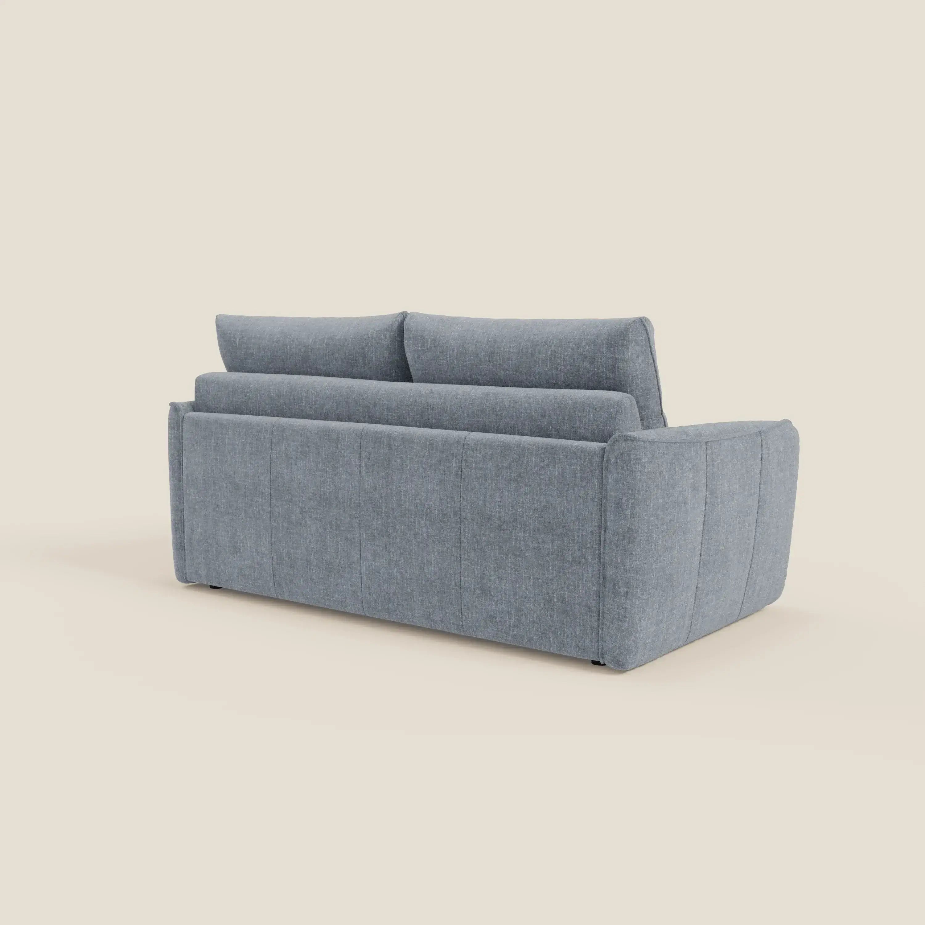 Il divano letto Elios di Divani.Store, presentato dallo schienale con morbidi cuscini, ampi braccioli, cuciture verticali e tessuto smacchiabile T24 carta da zucchero, si staglia su uno sfondo beige chiaro.