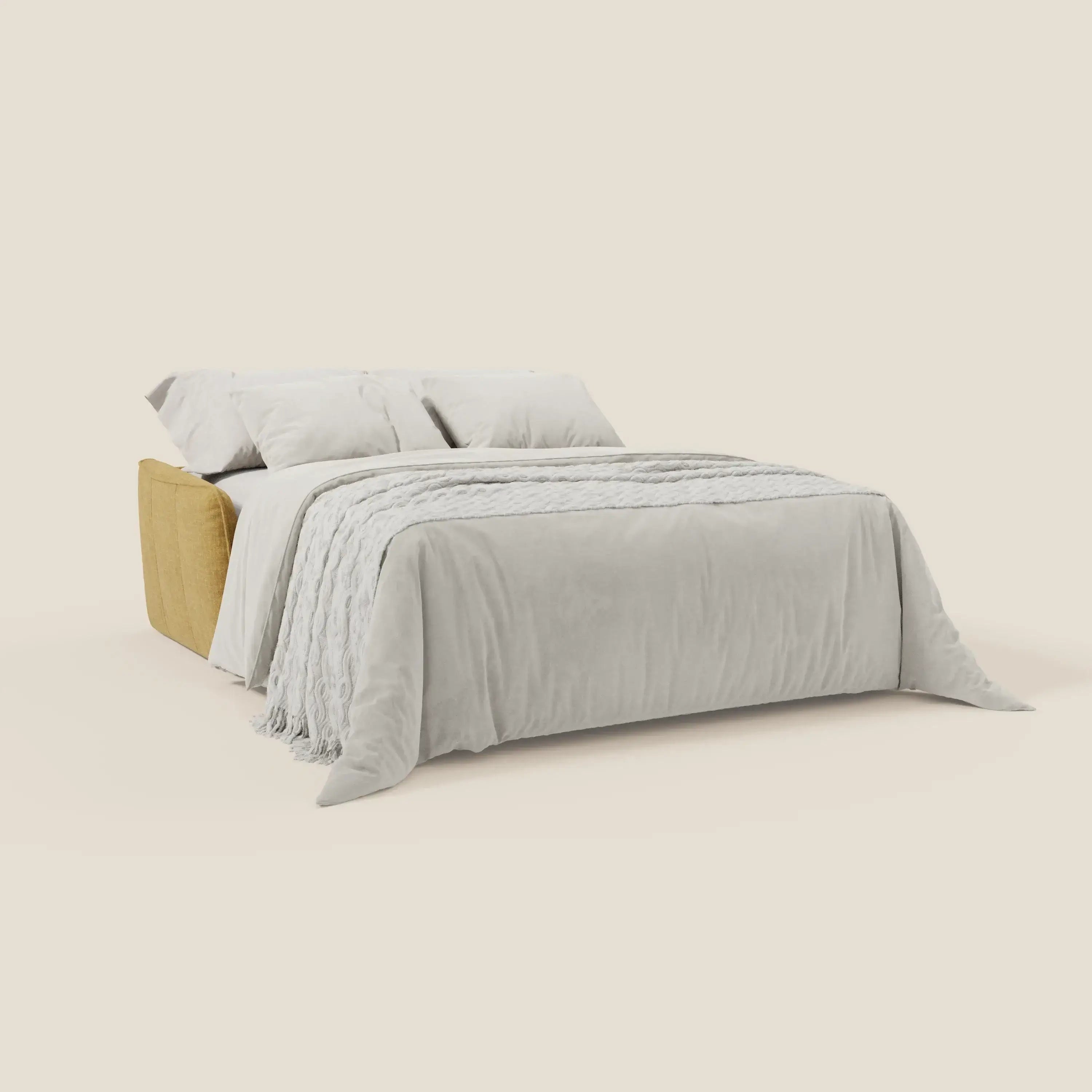 Elios Divano letto di Divani.Store è caratterizzato da morbidi cuscini di schienale e da una base in tessuto giallo T24 lavabile, sormontata da una biancheria beige chiaro e da due cuscini, che creano un look accogliente su uno sfondo crema.