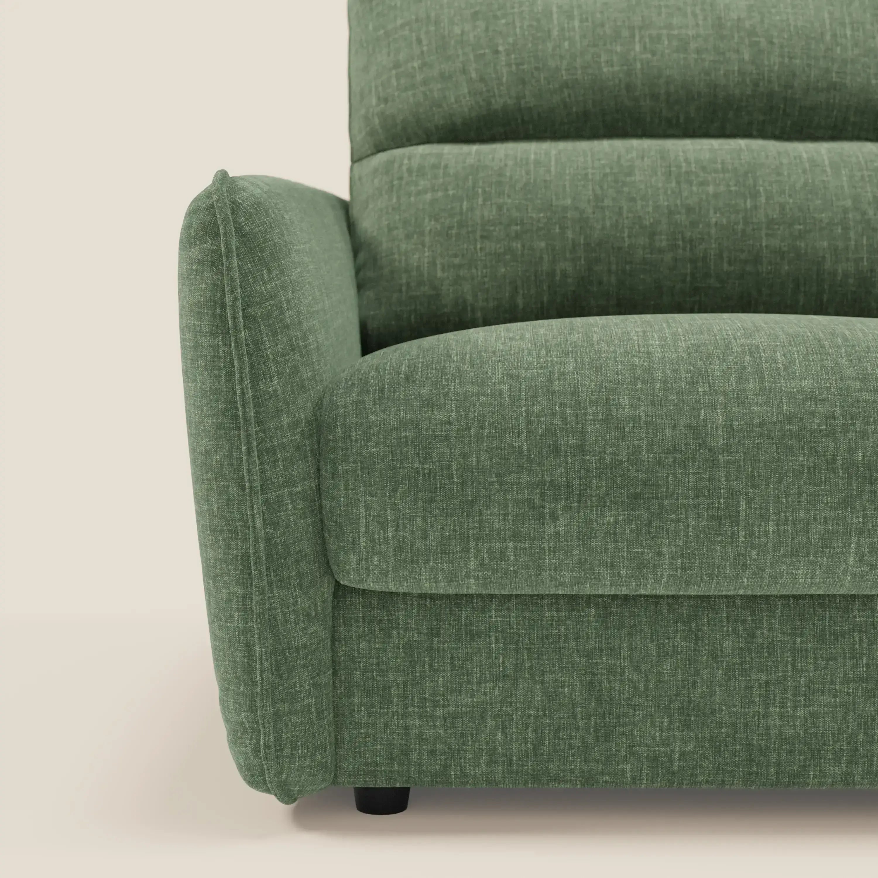 Primo piano del lato sinistro di Elios Divano letto con morbidi cuscini spalliera in tessuto smacchiabile T24 verde oliva di Divani.Store. Il bracciolo morbido, gli spessi cuscini e le corte gambe in legno scuro spiccano su uno sfondo chiaro.