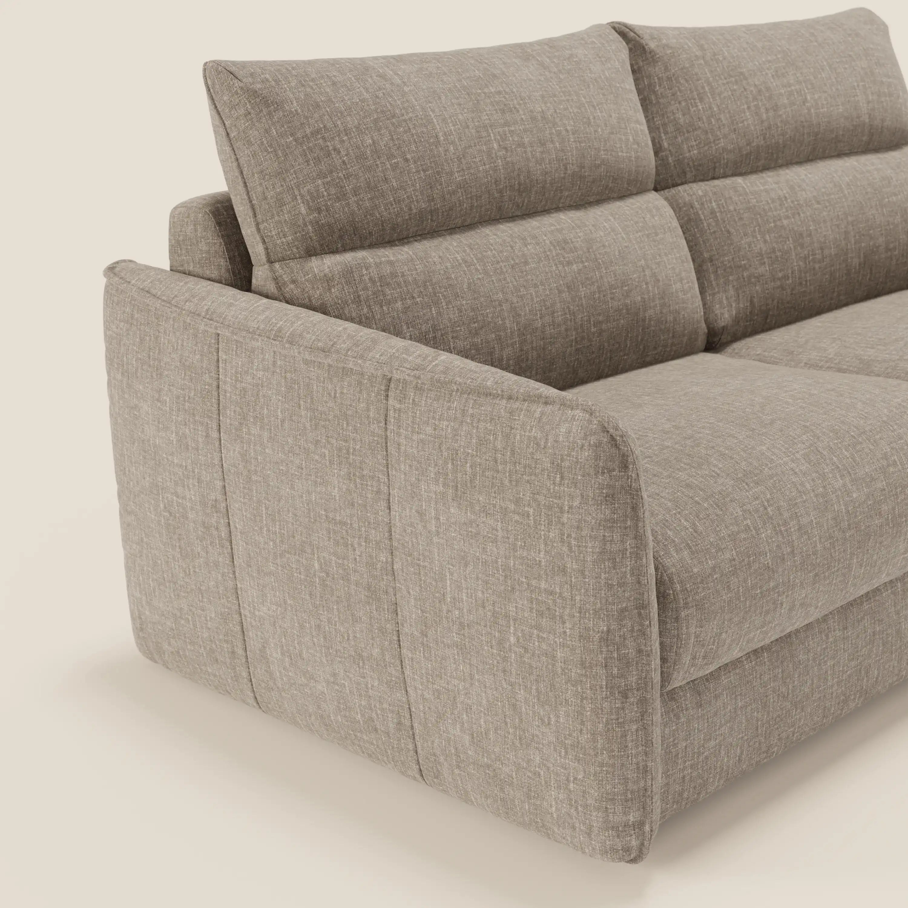 Una vista angolata e ravvicinata del divano letto Elios con morbidi cuscini spalliera in tessuto smacchiabile T24 marrone tortora di Divani.Store. Gli spessi cuscini e gli ampi braccioli offrono comfort e stile su un semplice sfondo beige.