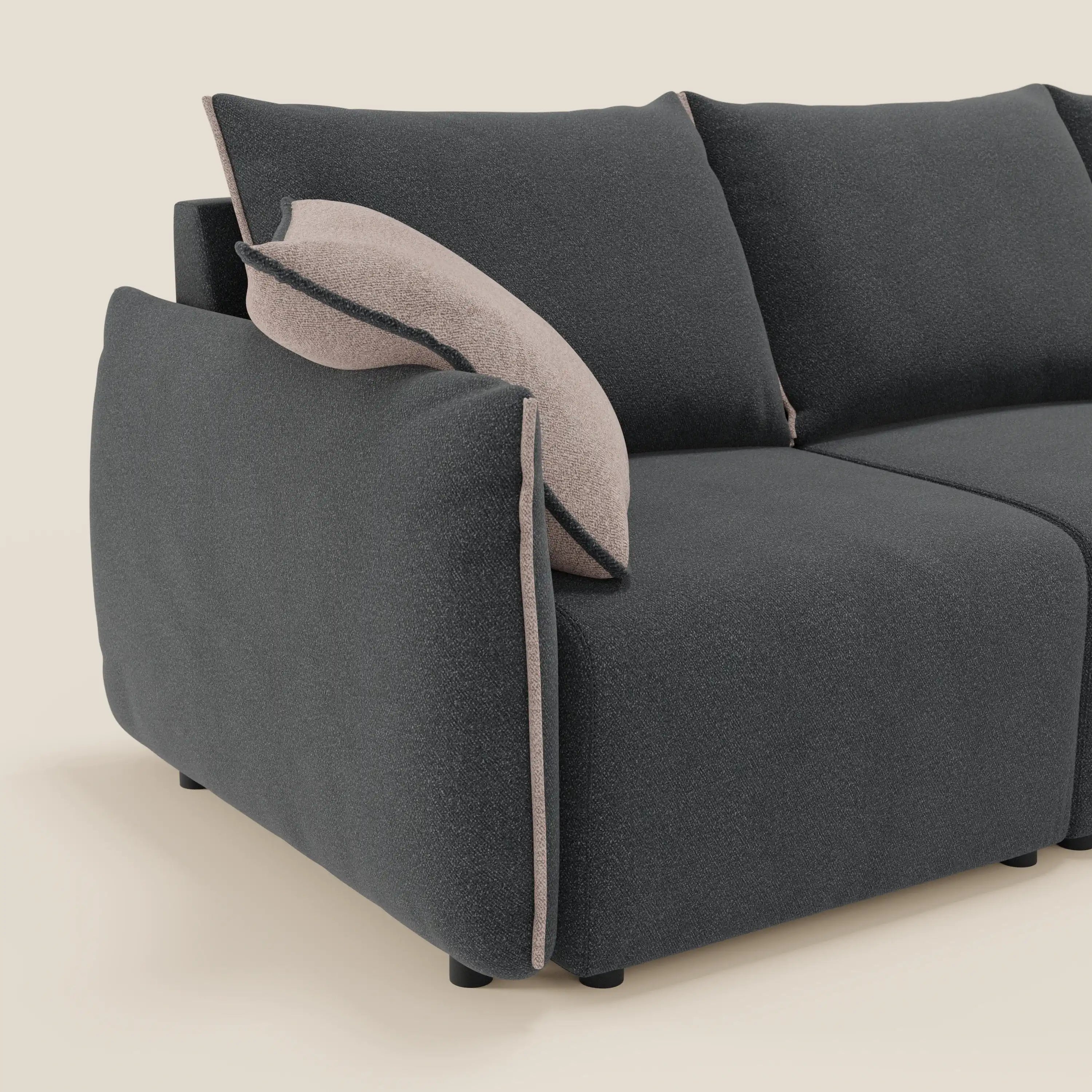 Flexar Divano angolare reversibile di Divani.Store è caratterizzato da una spessa imbottitura in bouclé antracite con profili beige chiaro e cuscino beige coordinato. Sedute allungabili e uno sfondo neutro bianco sporco completano il suo look moderno.