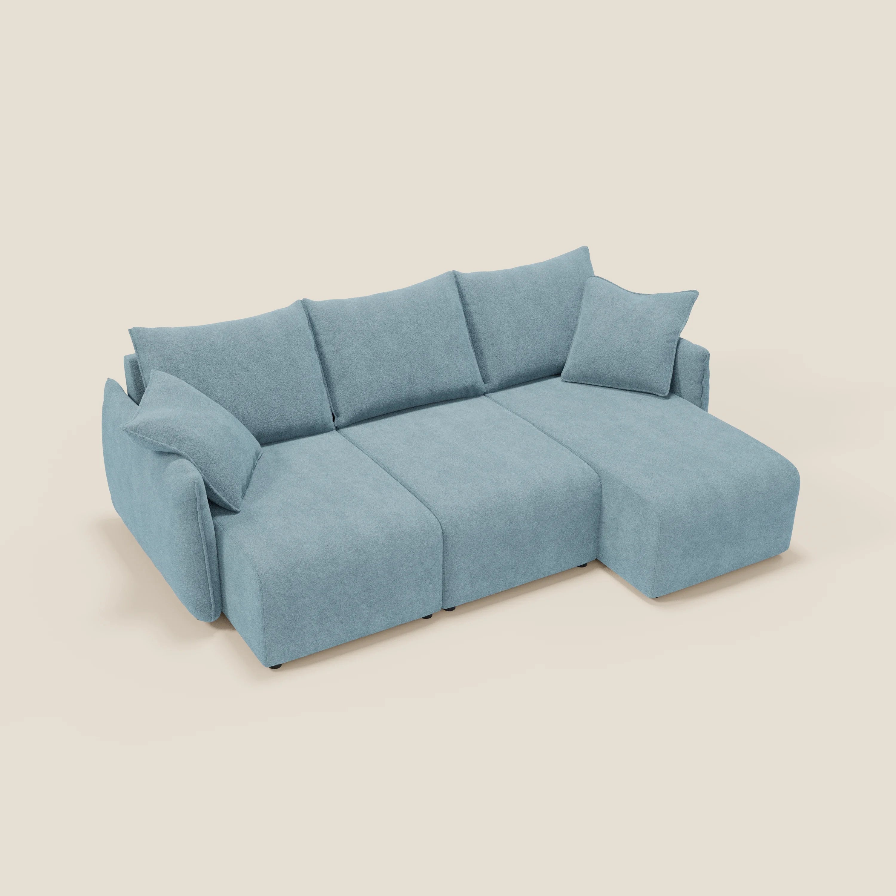 Il Divano angolare reversibile Flexar di Divani.Store, in bouclé morbido impermeabile T07 carta da zucchero, offre tre sedute allungabili, quattro grandi schienali, due braccioli, chaise longue destra e cuscini coordinati su sfondo beige.