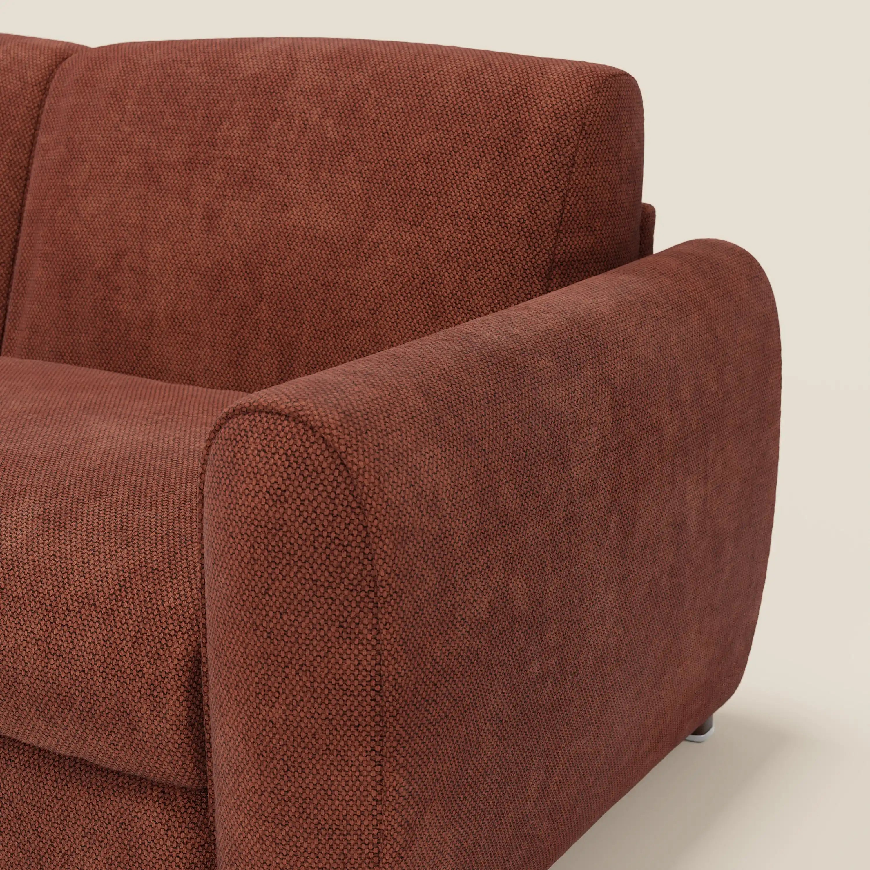 Primo piano del braccio destro e dello schienale di Kaleo Divano letto moderno di Divani.Store, rivestito in tessuto impermeabile T26 arancione ruggine. Il bracciolo ampio e arrotondato e le gambe corte in metallo ne esaltano lo stile contemporaneo.