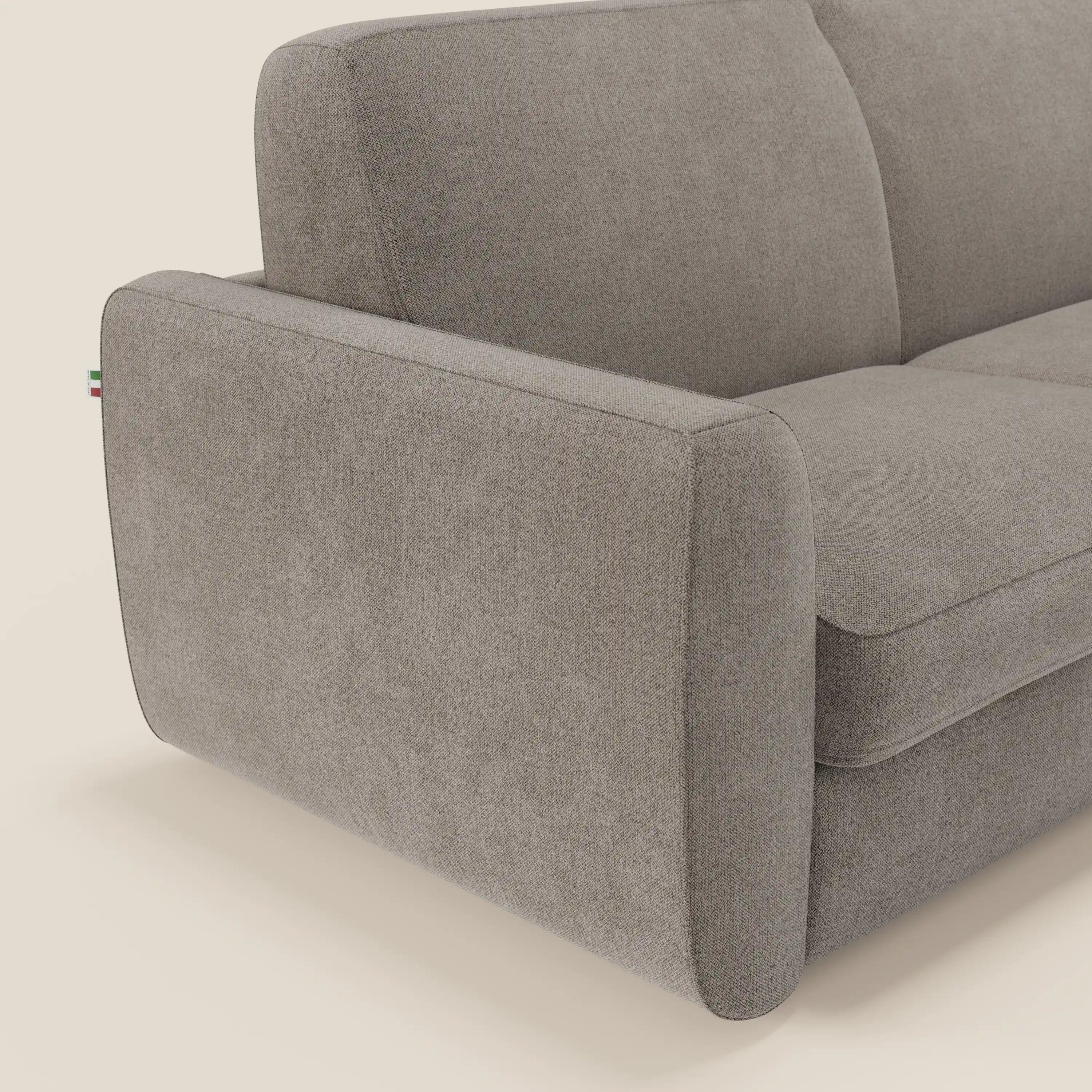 Primo piano del divano letto sfoderabile Leonida di Divani.Store in tessuto Smacchiabile T23 talpa, caratterizzato da cuscini morbidi, ampi braccioli arrotondati, targhetta in tessuto a righe italiane e meccanismo in acciaio rinforzato per una maggiore durata.