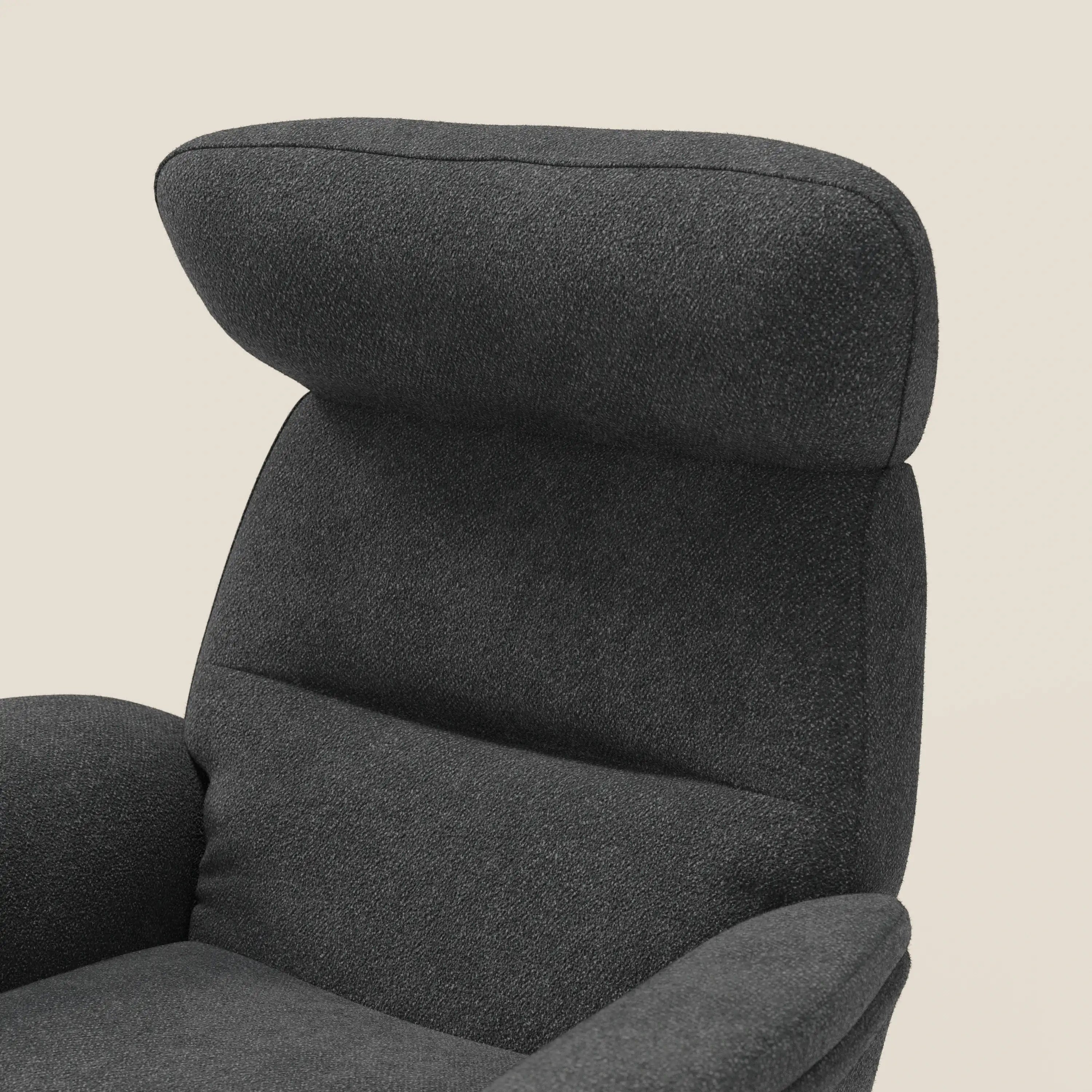 Primo piano della poltrona relax Divani.Store Lunor reclinabile con pouf poggiapiedi in tessuto bouclé impermeabile T07 antracite, con schienale alto e imbottito, poggiatesta integrato e braccioli curvi su sfondo beige chiaro.
