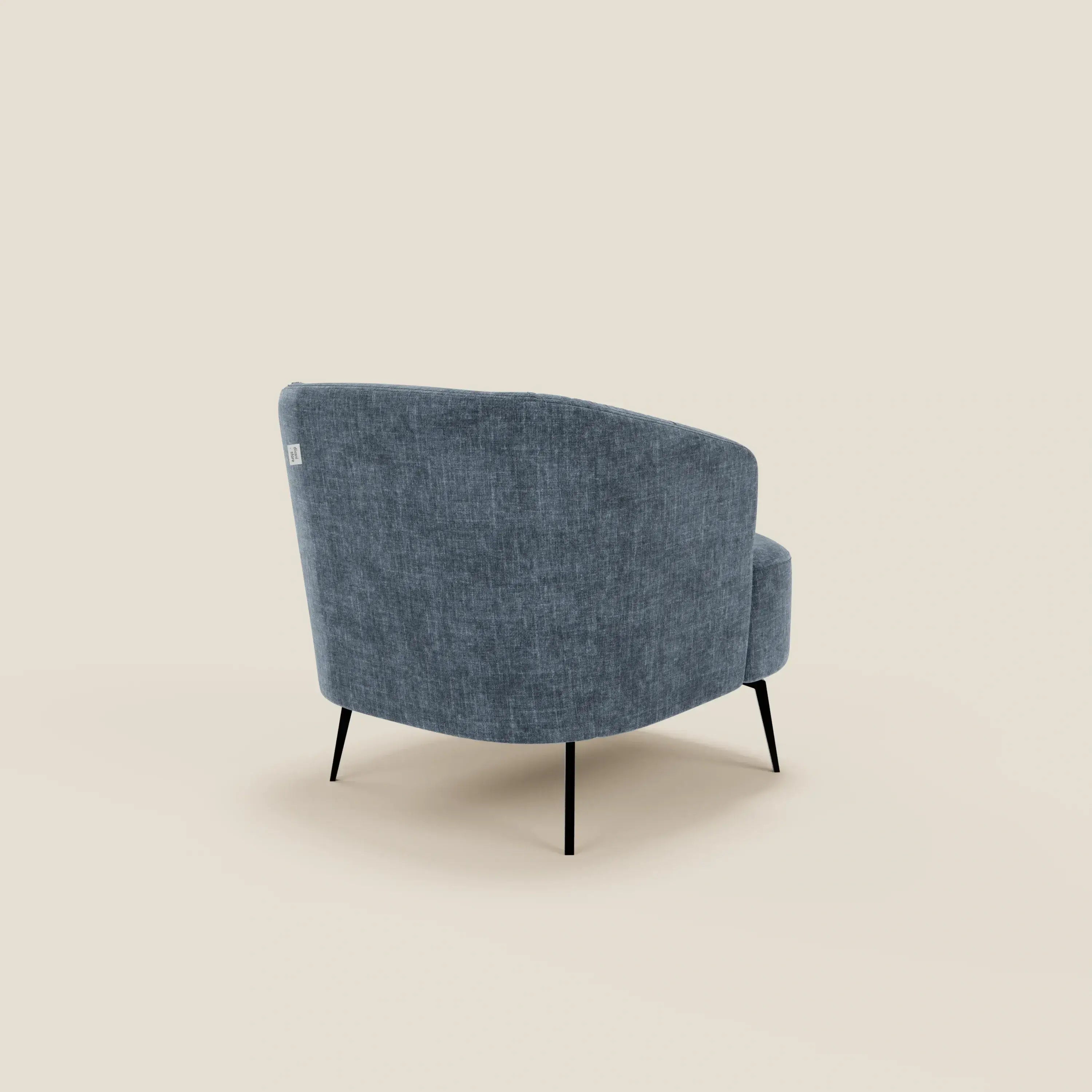 La poltroncina Renoa dall'eleganza moderna in tessuto smacchiabile T24 blu ardesia di Divani.Store è caratterizzata da uno schienale curvo e da sottili gambe in metallo nero, presentate ad angolo su uno sfondo beige per un look minimalista e contemporaneo.