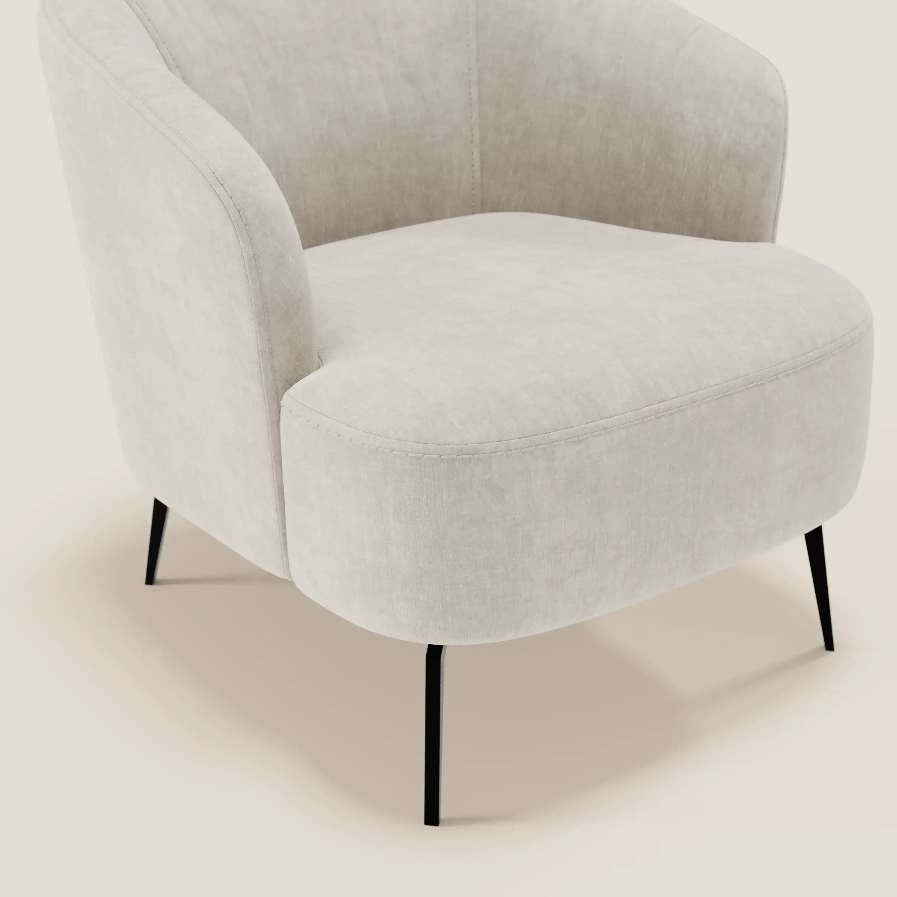 La poltroncina Renoa di Divani.Store è caratterizzata da un tessuto smacchiabile T24 bianco latte, uno schienale curvo e una seduta arrotondata. Le sottili gambe in metallo nero ne evidenziano lo stile moderno e l'eleganza minimalista. Solo una parte della sedia è visibile.