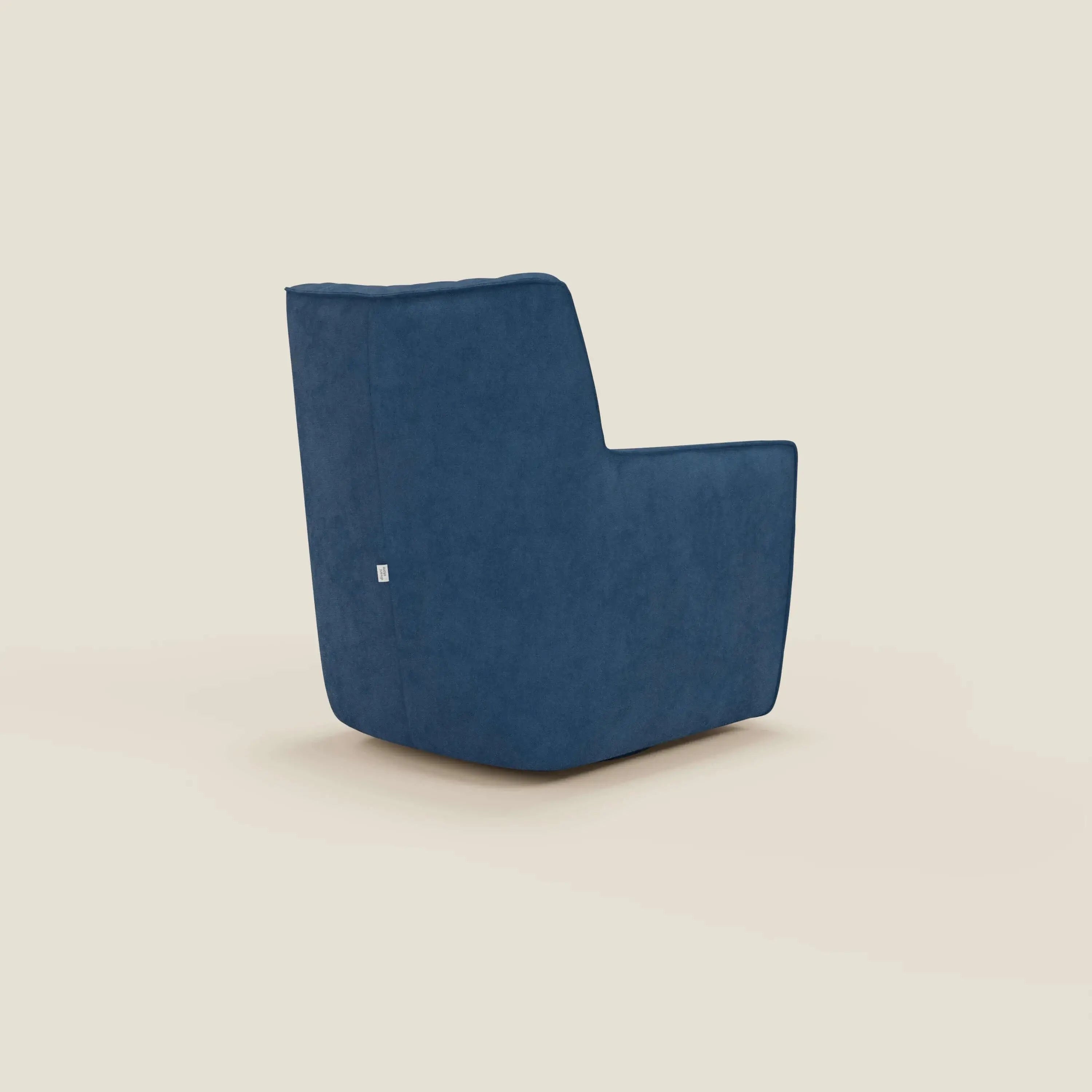 La poltrona girevole Tulla in tessuto impermeabile T02 blu di Divani.Store, presentata in posizione angolare su sfondo crema chiaro, presenta un design moderno e squadrato, linee pulite, rivestimento blu morbido, profilo basso e una piccola etichetta laterale bianca.