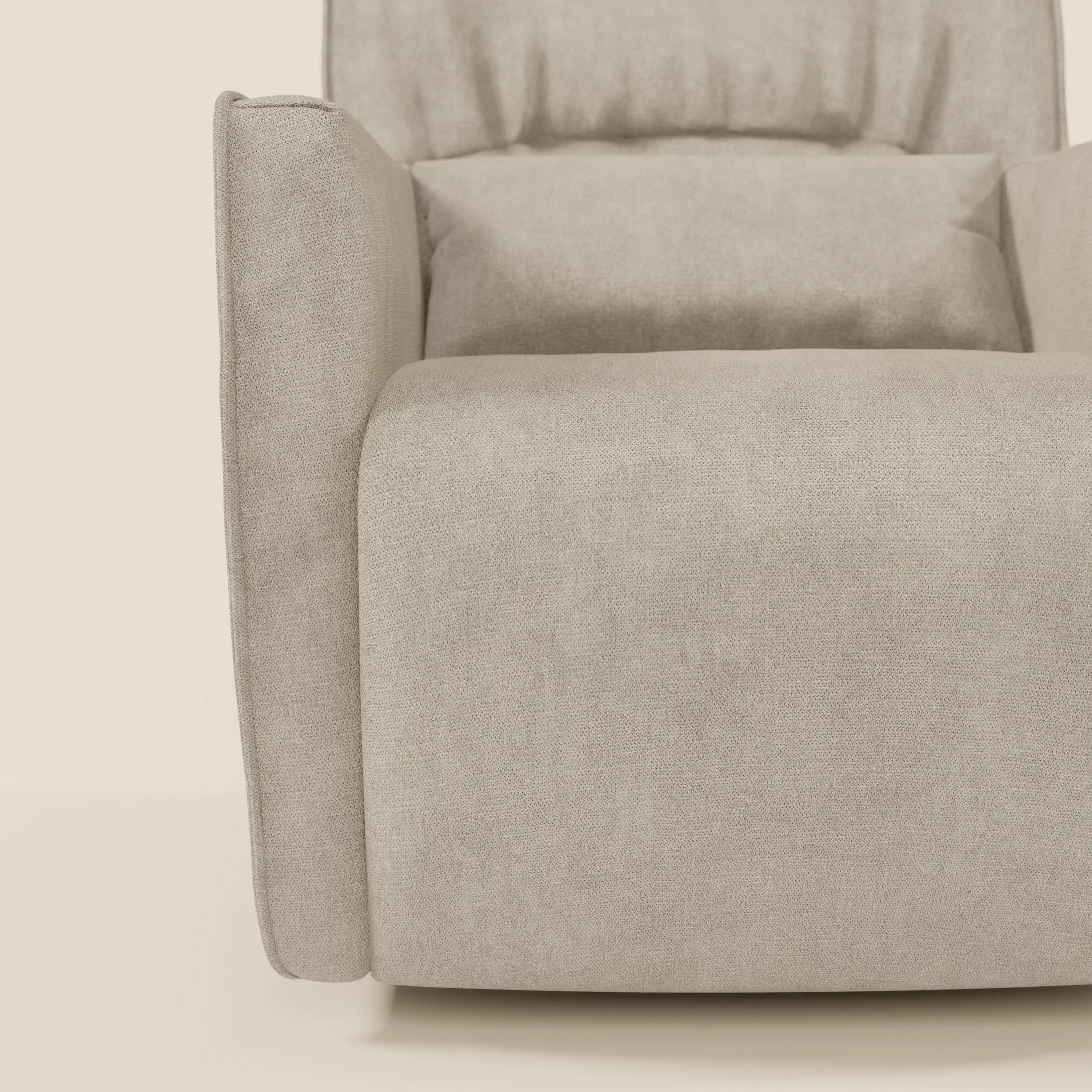 Un primo piano di Tulla Poltrona girevole in tessuto impermeabile T02 panna di Divani.Store mostra il bracciolo sinistro, la seduta imbottita e parte dell'alto schienale imbottito su uno sfondo chiaro.