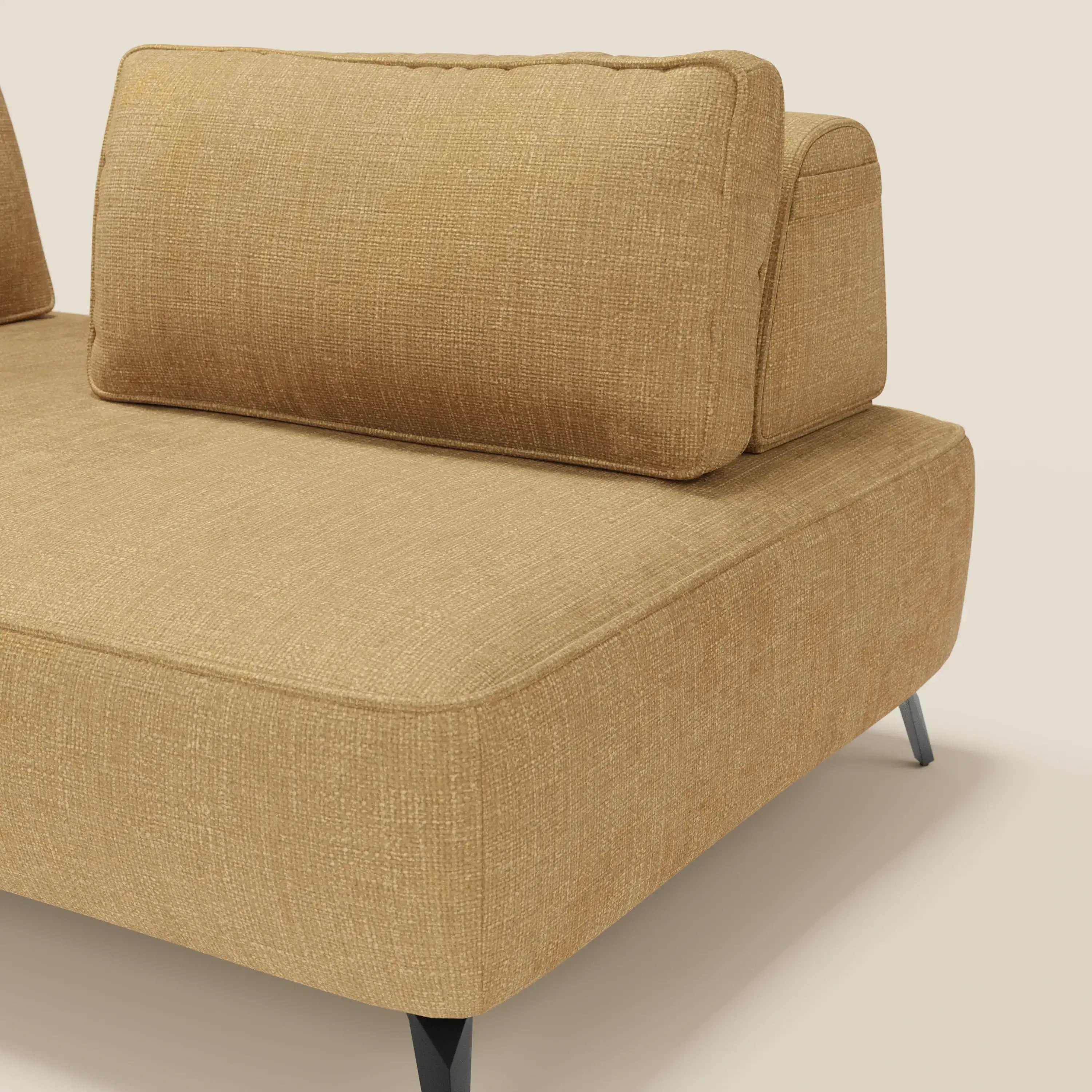 Un primo piano del divano modulare Volta di Divani.Store, rivestito in raffinato tessuto ciniglia T06 giallo. L'immagine mette in evidenza l'angolo del divano con le gambe in metallo angolate nere e la spessa seduta e i cuscini schienali mobili su uno sfondo crema chiaro.