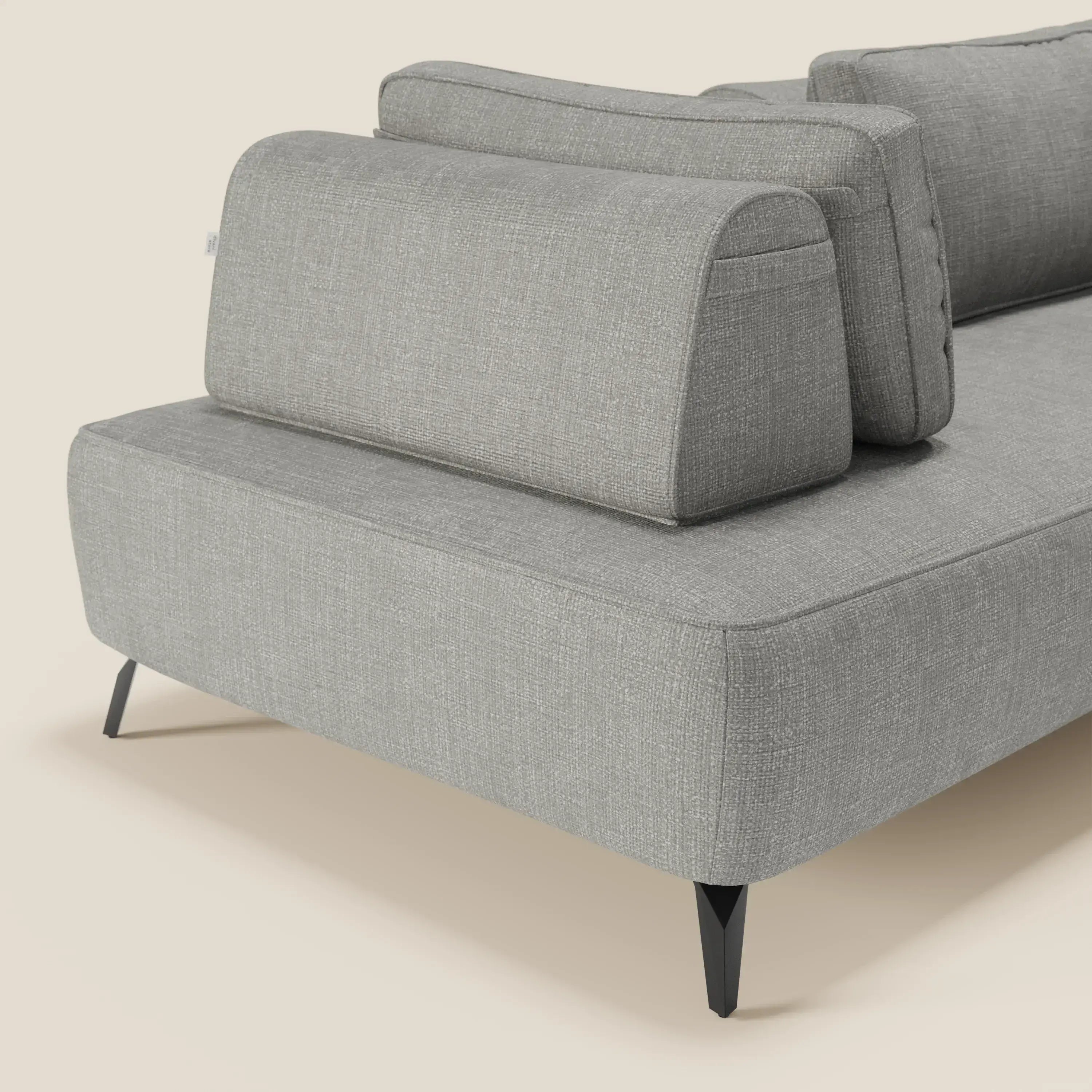 Volta divano modulare di Divani.Store con schienali mobili in pregiato tessuto ciniglia T06 grigio, seduti su sottili gambe nere. Lo sfondo beige valorizza il suo design contemporaneo.