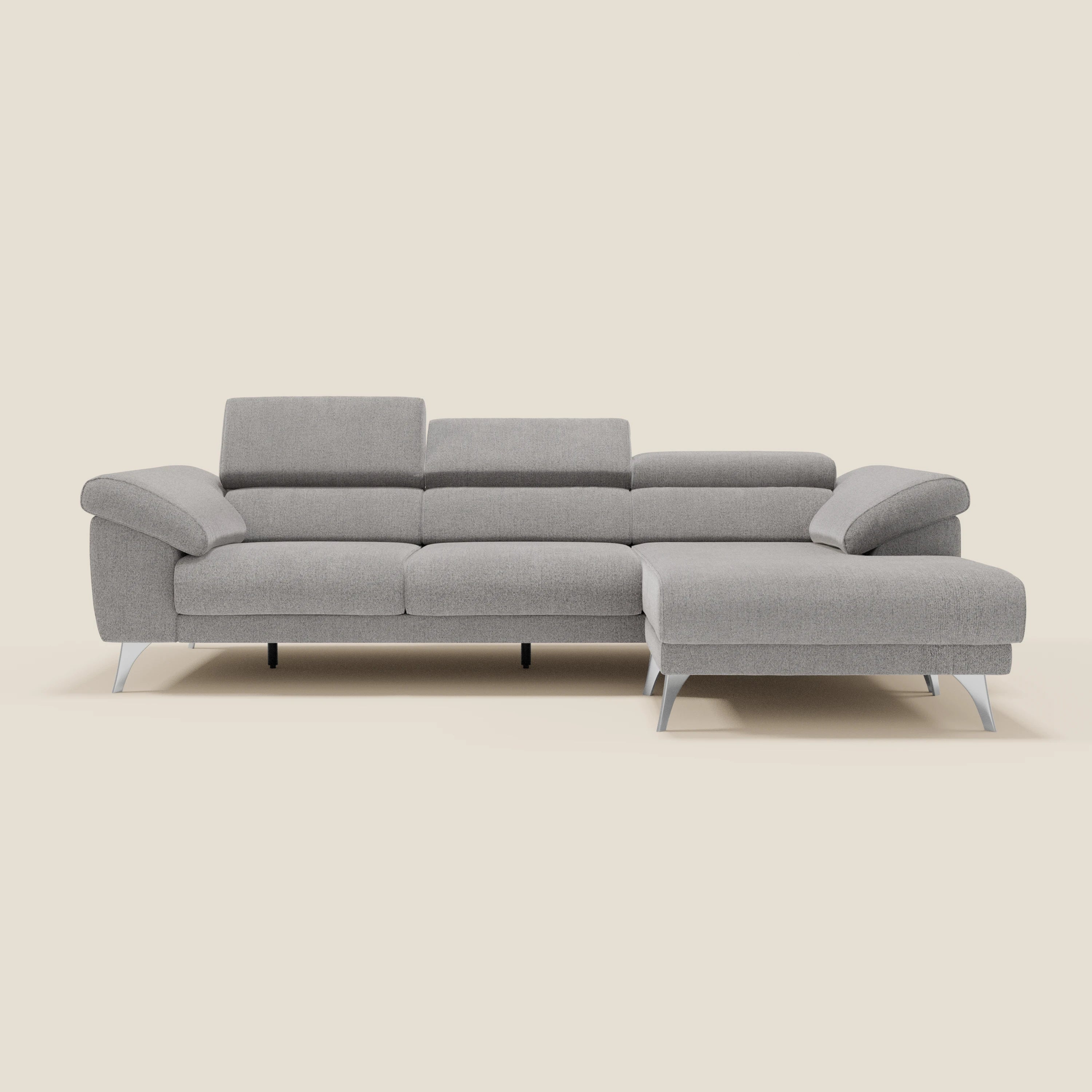 Il Divano angolare Donatello di Divani.Store in grigio chiaro T23 è caratterizzato da sedute scorrevoli, braccioli contenitori e poggiatesta regolabili per il massimo comfort, su uno sfondo bianco sporco con gambe angolari in metallo argentato.