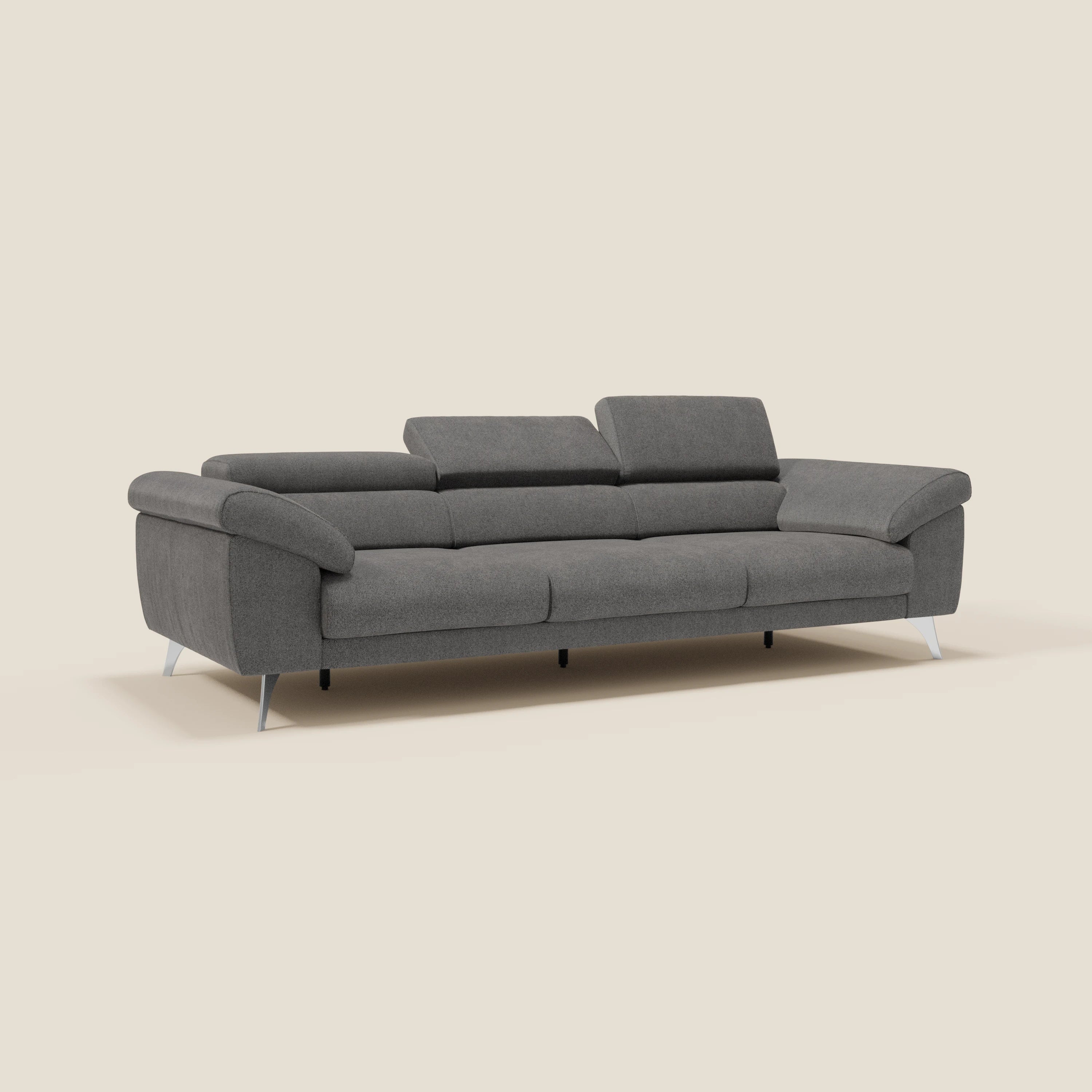 Il divano Donatello di Divani.Store è caratterizzato da 3 sedute allungabili, braccioli contenitore, poggiatesta reclinabili e tessuto smacchiabile antracite T23, che offre un comfort intelligente su uno sfondo beige semplice.