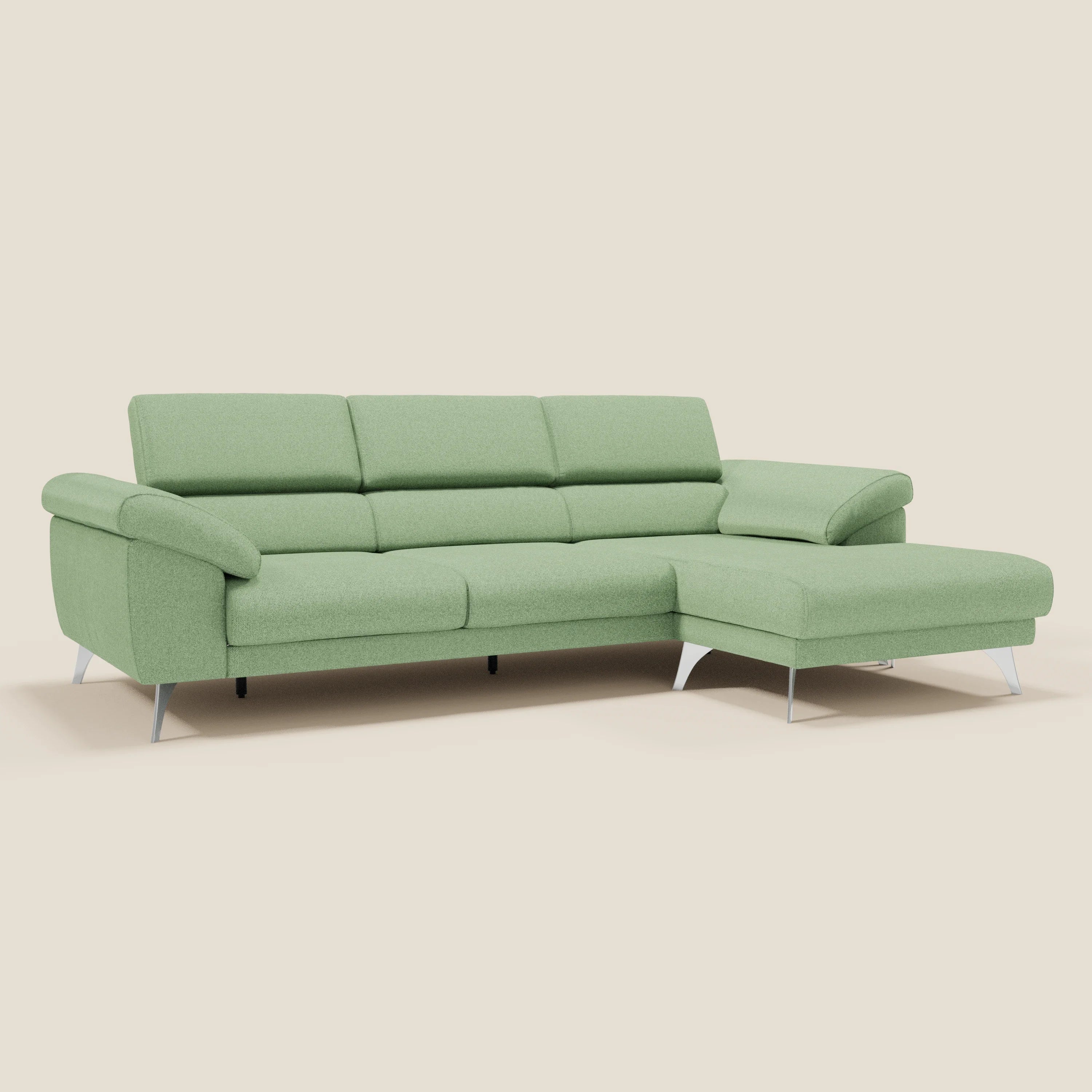 Il Divano angolare Donatello di Divani.Store, in morbido tessuto antimacchia T23 menta, è caratterizzato da sedute scorrevoli, braccioli portaoggetti, poggiatesta regolabili e chaise longue sul lato destro per un comfort e uno stile minimalista su sfondo beige.