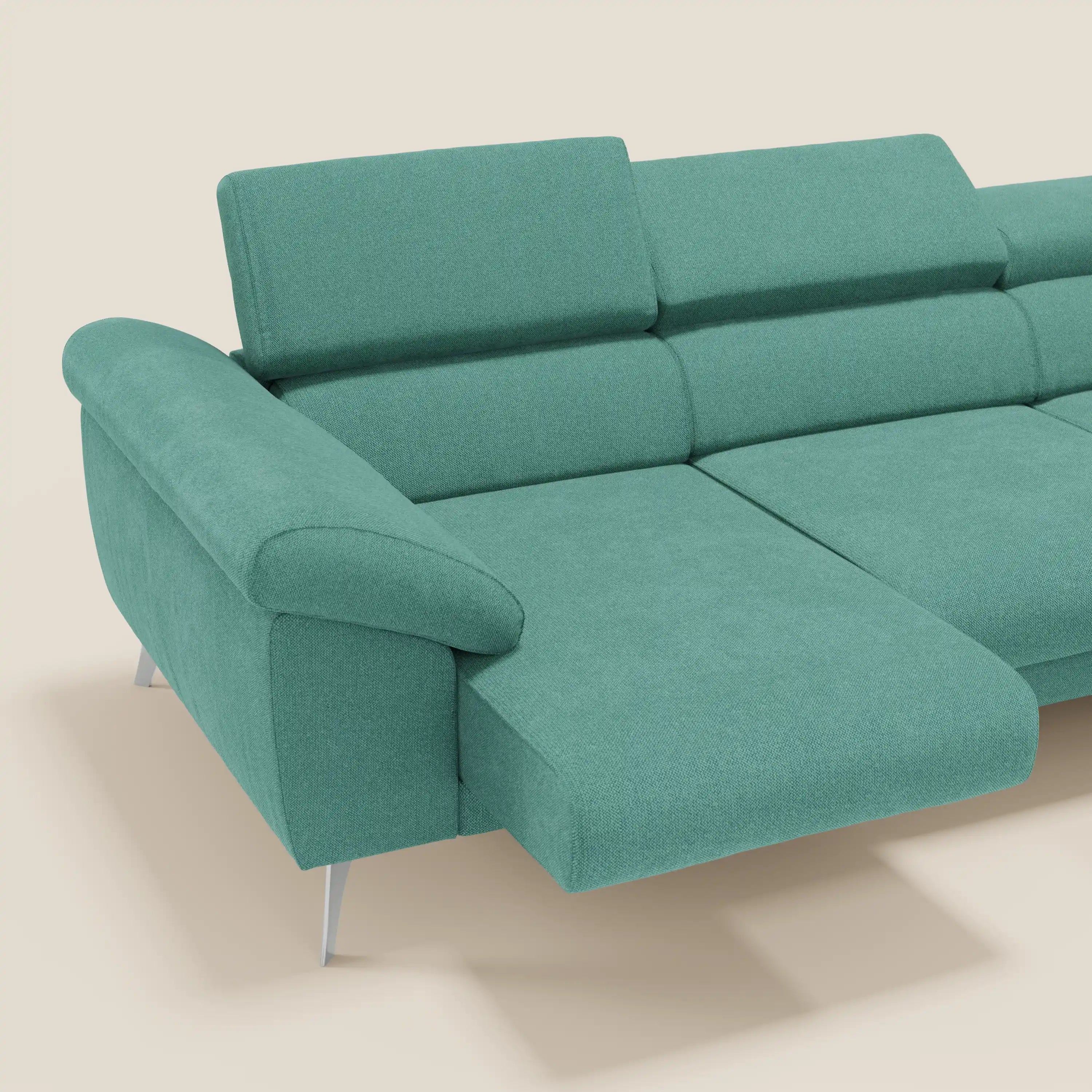 Il Divano angolare Donatello di Divani.Store, in tessuto smacchiabile T23 verde acqua con sedute scorrevoli, braccioli contenitori e poggiatesta regolabili, è caratterizzato da un design elegante ed è presentato con il bracciolo e la chaise di sinistra su sfondo beige.