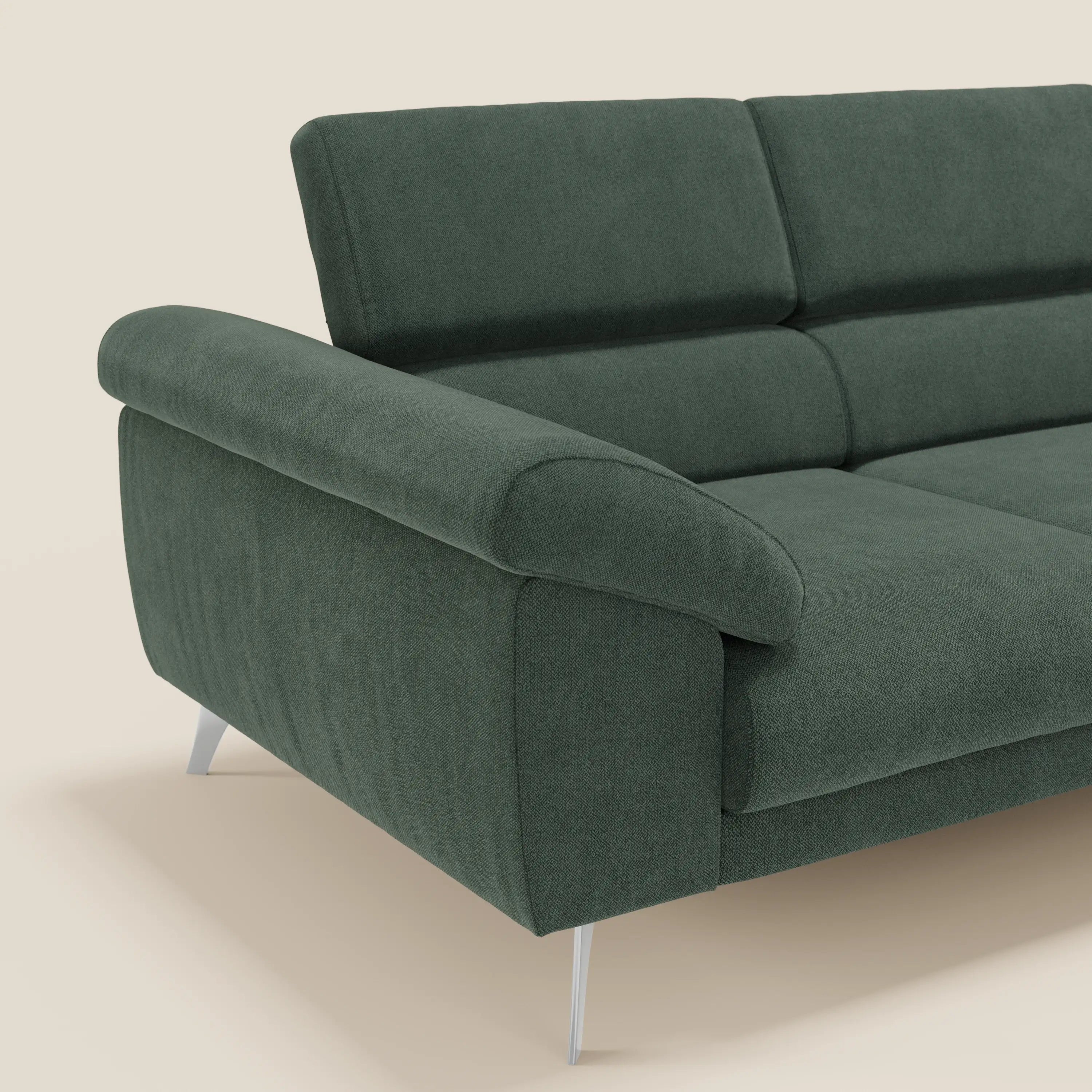 Il divano Donatello di Divani.Store è dotato di 3 sedute estensibili, braccioli contenitori e poggiatesta regolabili in tessuto verde T23 antimacchia, che combinano comfort moderno e stile minimal con eleganti gambe in metallo, perfette su uno sfondo beige chiaro.