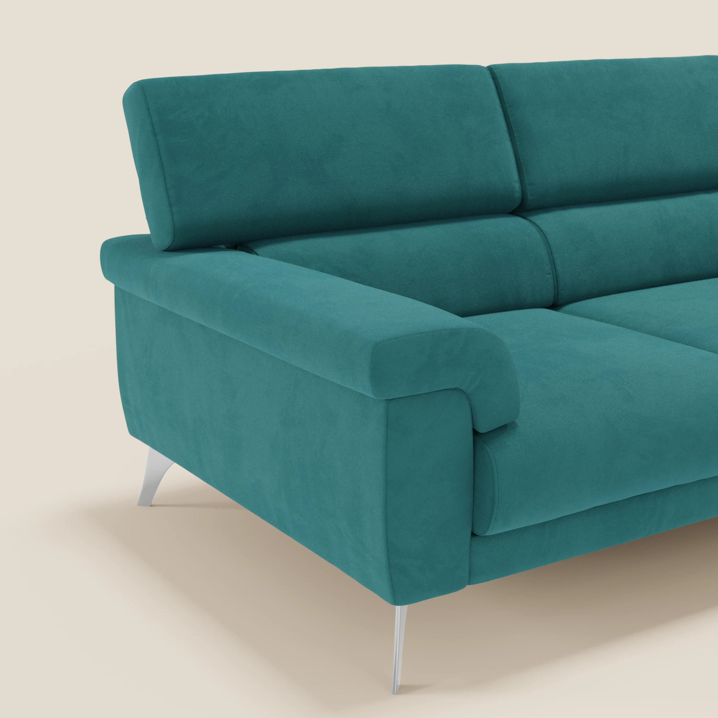 Il divano angolare Raffaello di Divani.Store in microfibra T11 petrolio è caratterizzato da sedute scorrevoli, poggiatesta regolabili, ampi braccioli e gambe in metallo argentato. Presentato su uno sfondo beige semplice, con solo il lato sinistro e parte della seduta visibili.