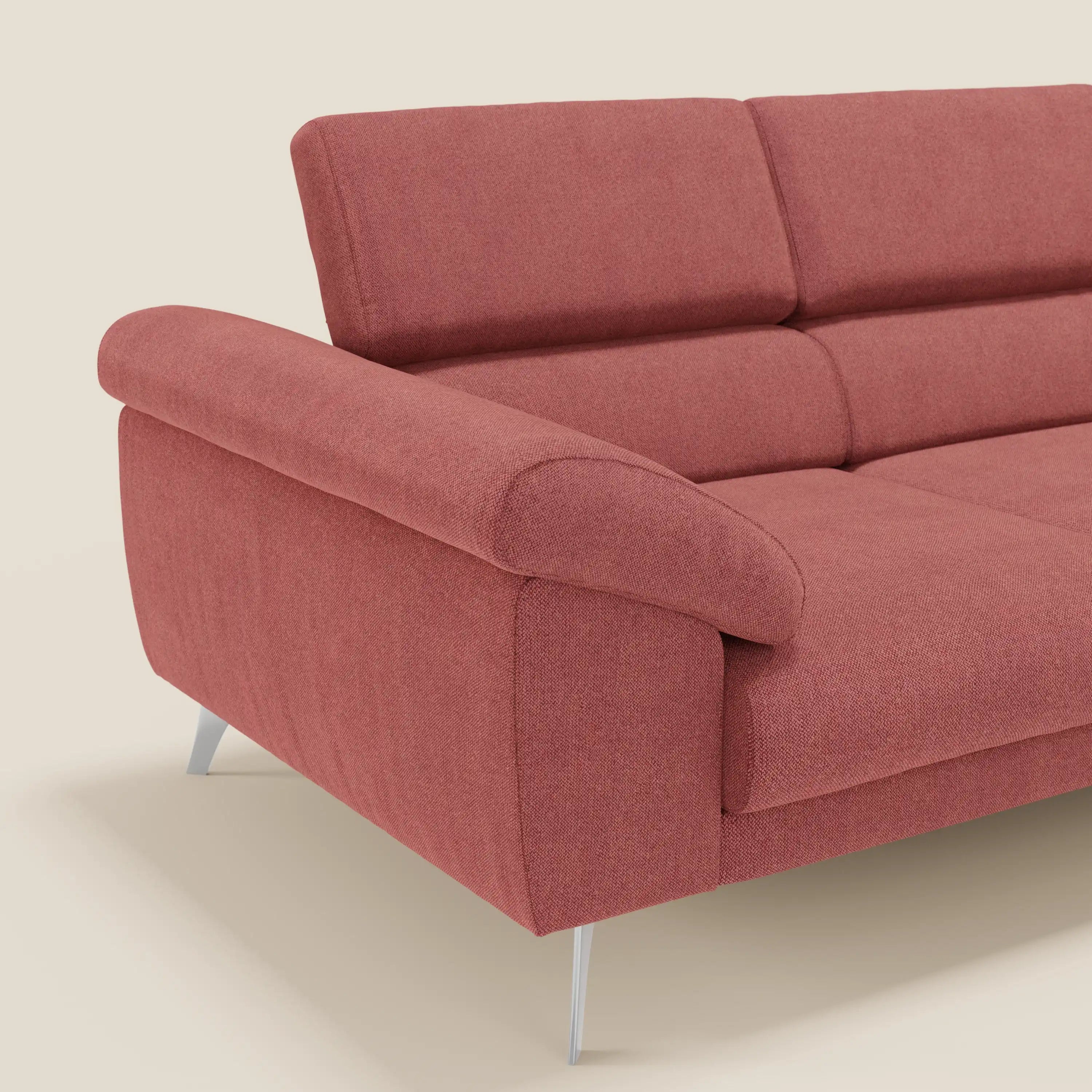 Il divano Donatello di Divani.Store è caratterizzato da 3 sedute regolabili, braccioli contenitori e poggiatesta reclinabili in tessuto T23 rosso ciliegia antimacchia. Le gambe in metallo, inclinate a sinistra, spiccano su uno sfondo beige chiaro.