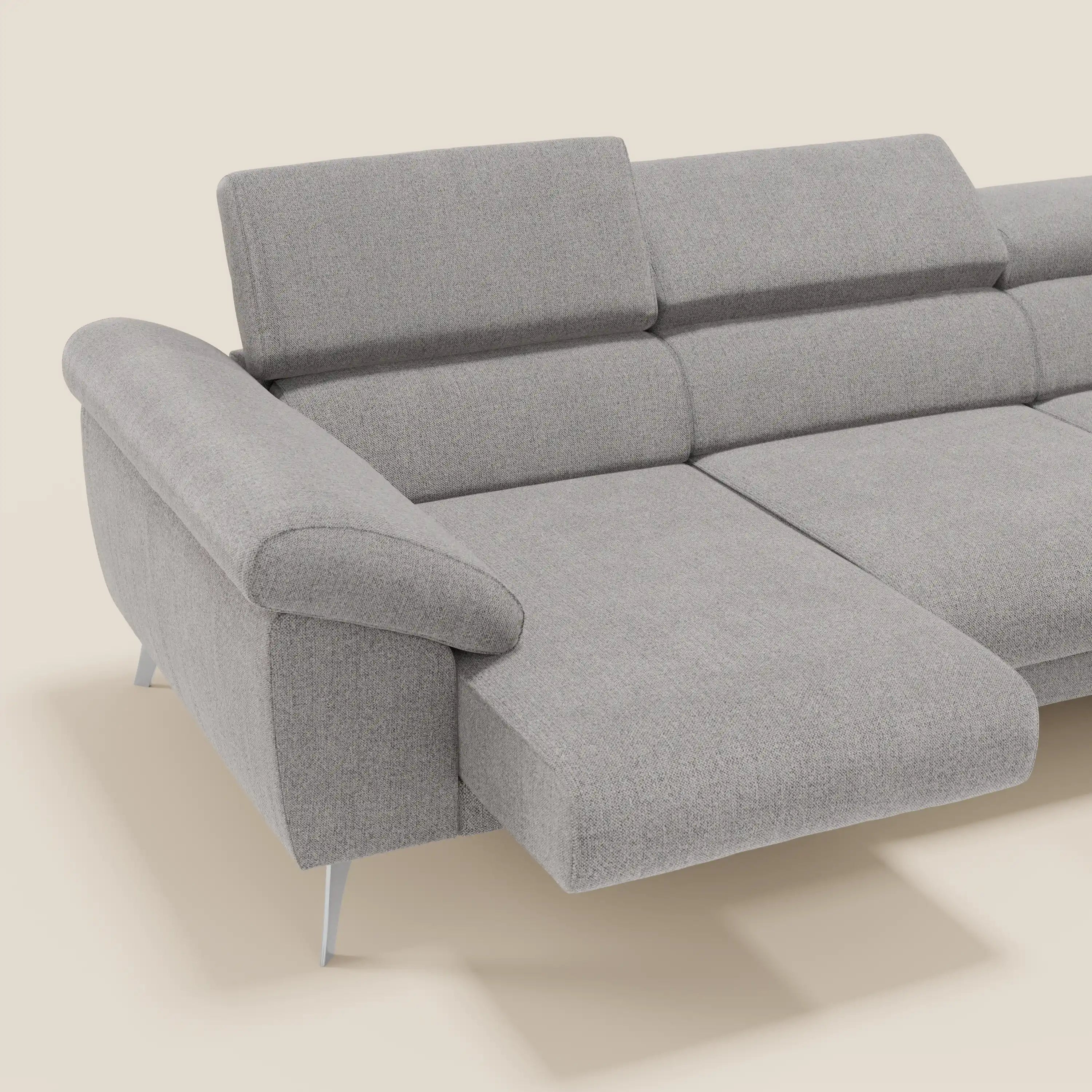 Donatello Divano angolare di Divani.Store in morbido tessuto grigio T23 antimacchia, è dotato di sedute scorrevoli, braccioli portaoggetti, poggiatesta regolabili e chaise longue sinistra. Presenta uno sfondo bianco sporco.
