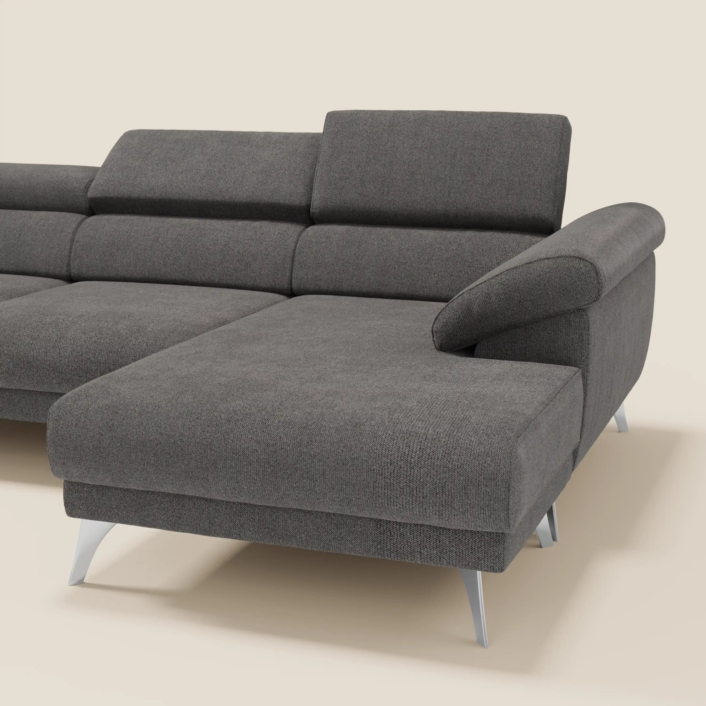 Il divano angolare Donatello di Divani.Store in tessuto T23 antracite smacchiabile è caratterizzato da ampie sedute imbottite con sedute scorrevoli, braccioli contenitore, poggiatesta reclinabili e gambe metalliche angolate con chaise lounge sul lato destro.