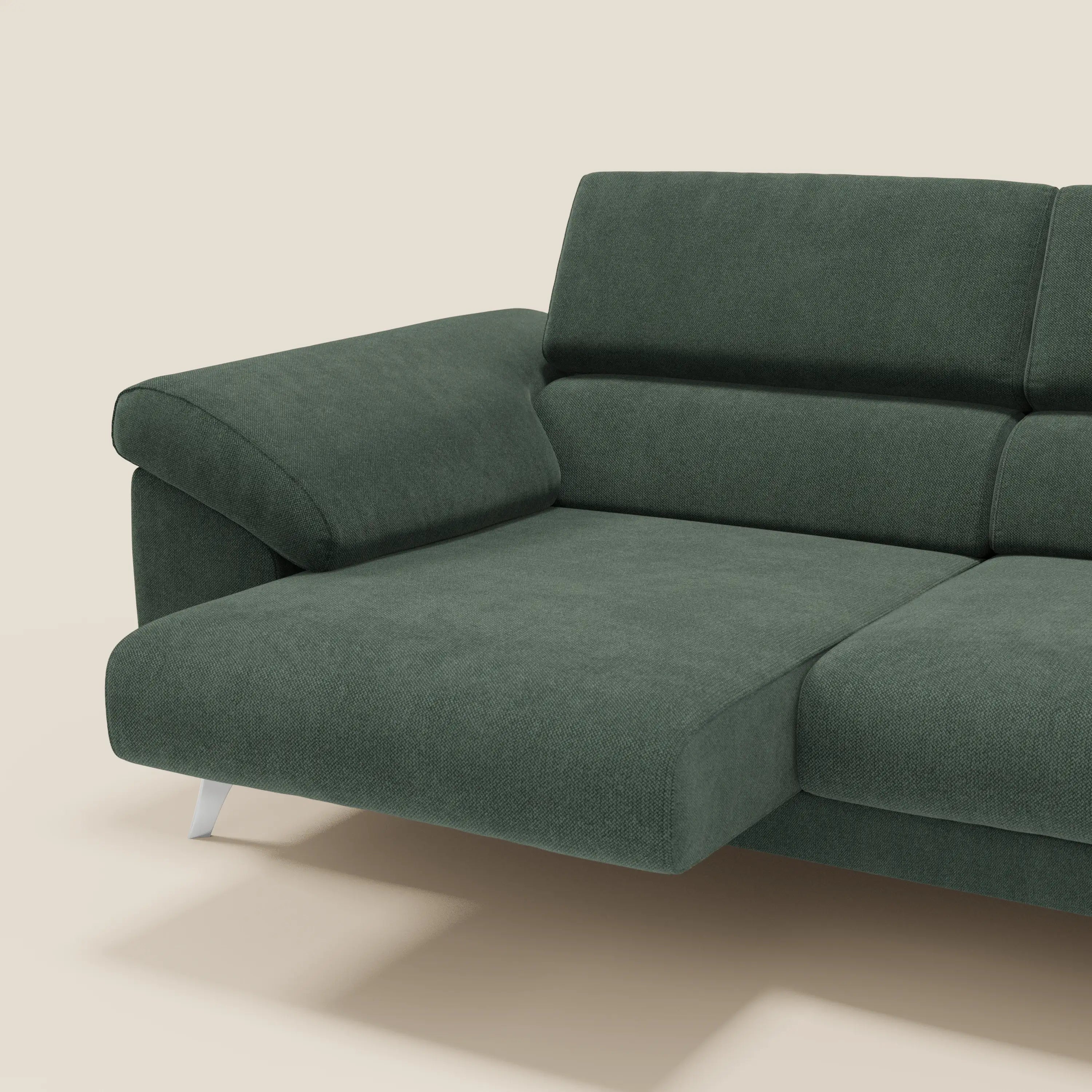 Il divano Donatello con sedute allungabili, braccioli contenitore e poggiatesta reclinabili in tessuto smacchiabile T23 verde di Divani.Store è mostrato su sfondo beige, con design moderno e dettagli contemporanei.