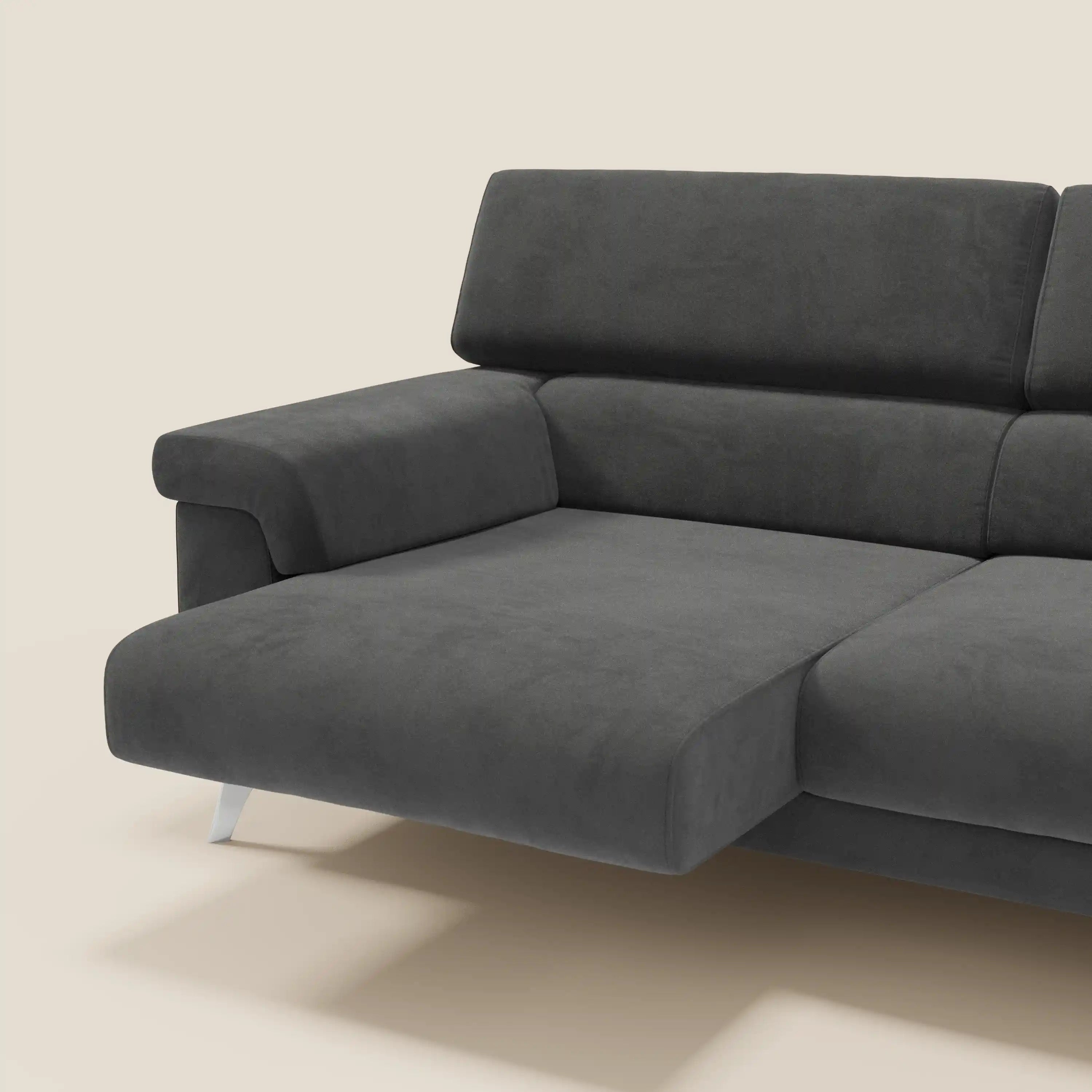 Primo piano del divano Raffaello di Divani.Store, caratterizzato da sedute allungabili e poggiatesta reclinabili in smacchiabile T11 nero microfibra, con chaise allungabile e gambe in metallo, su sfondo beige chiaro.