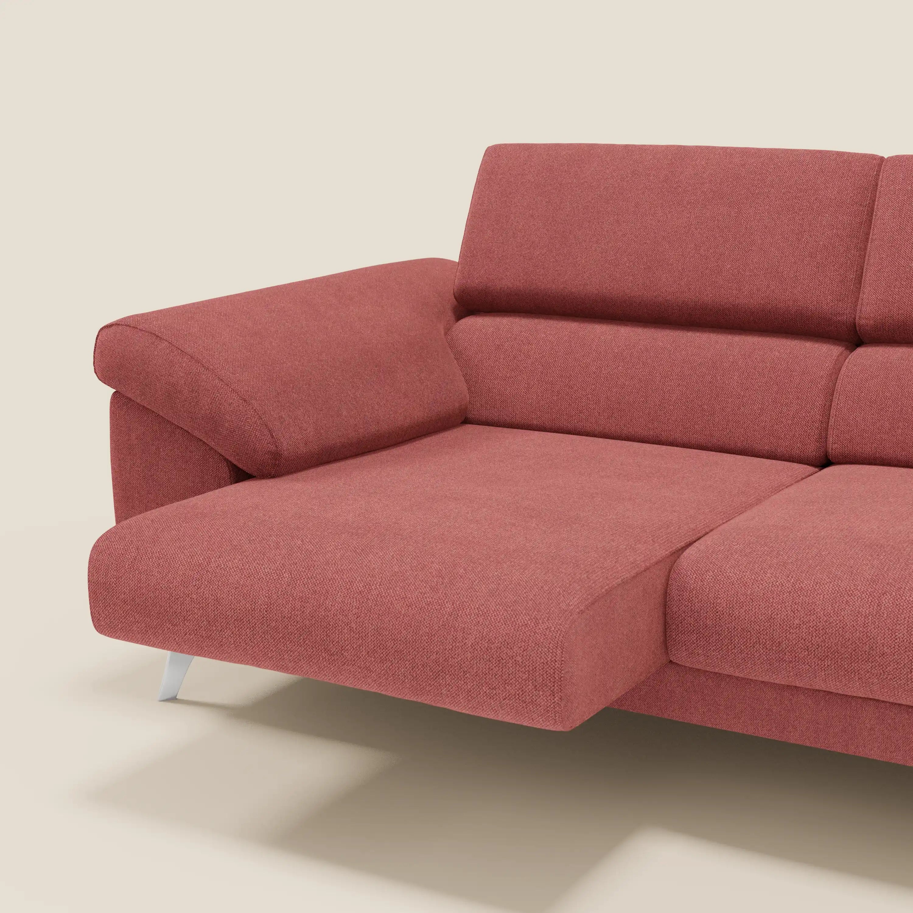 Il divano Donatello di Divani.Store, in tessuto smacchiabile T23 rosso ciliegia, è caratterizzato da sedute allungabili, braccioli contenitore e poggiatesta reclinabili: un mix di comfort e design contemporaneo su sfondo beige.