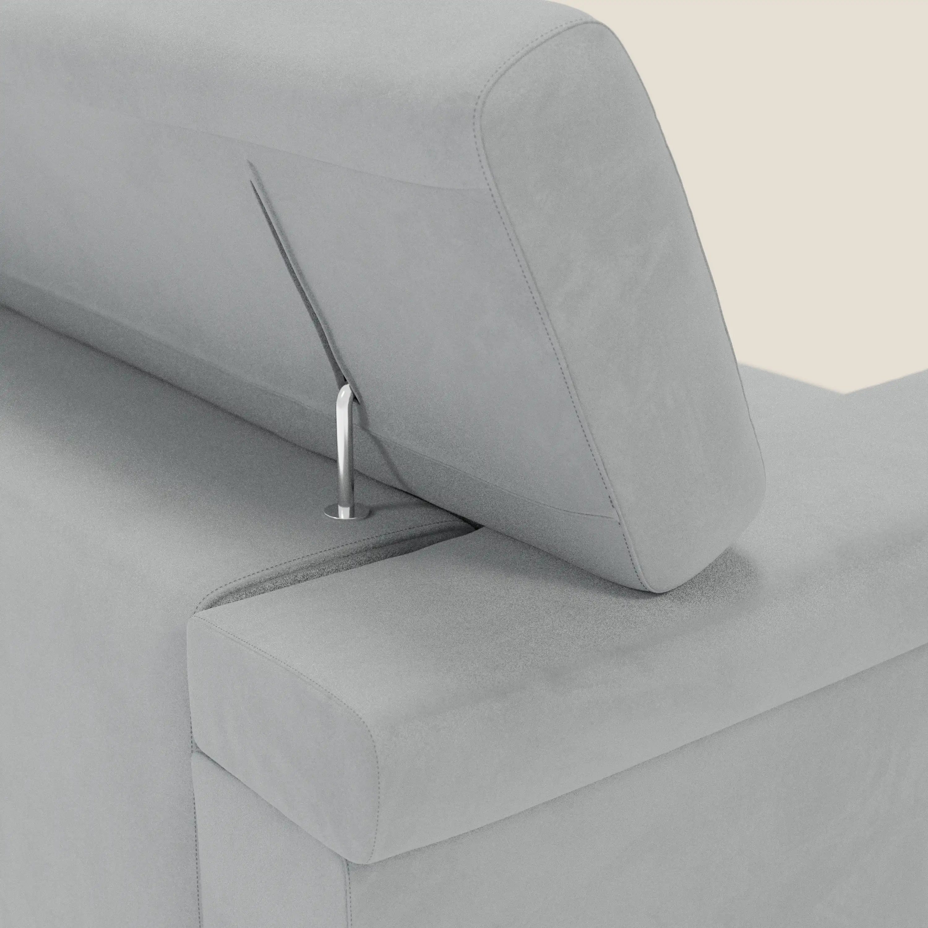 Un primo piano del divano Raffaello con sedute allungabili e poggiatesta reclinabili in microfibra smacchiabile T11 grigio chiaro di Divani.Store, la cui elegante asta metallica e il morbido rivestimento grigio chiaro evidenziano il design minimale e moderno del divano su uno sfondo beige semplice.