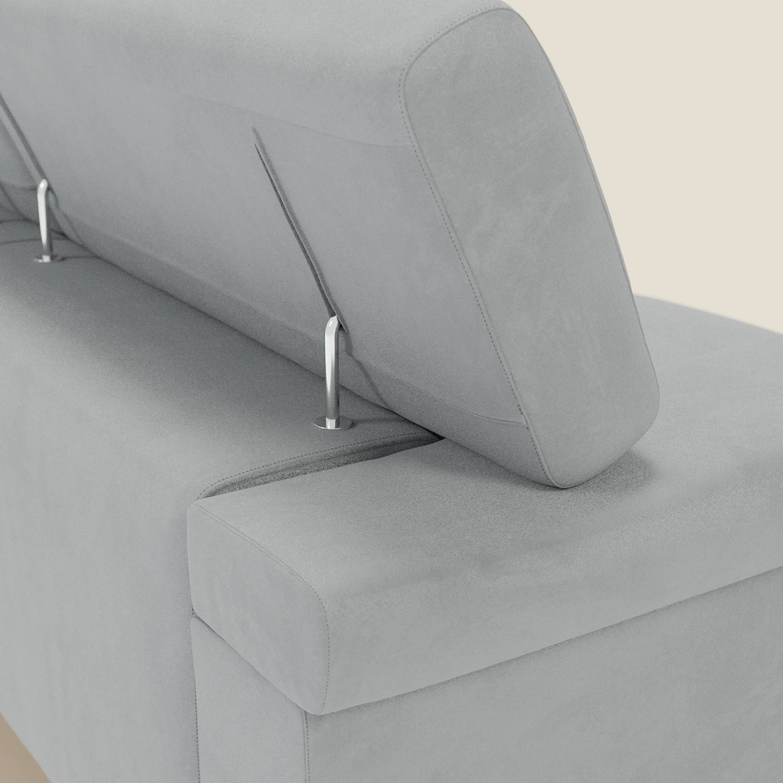 Un primo piano del divano Raffaello con 3 sedute allungabili e poggiatesta reclinabile in microfibra T11 grigio chiaro di Divani.Store mostra i poggiatesta regolabili, le sottili aste in metallo e il morbido tessuto antimacchia su uno sfondo beige. Prodotto in Italia.