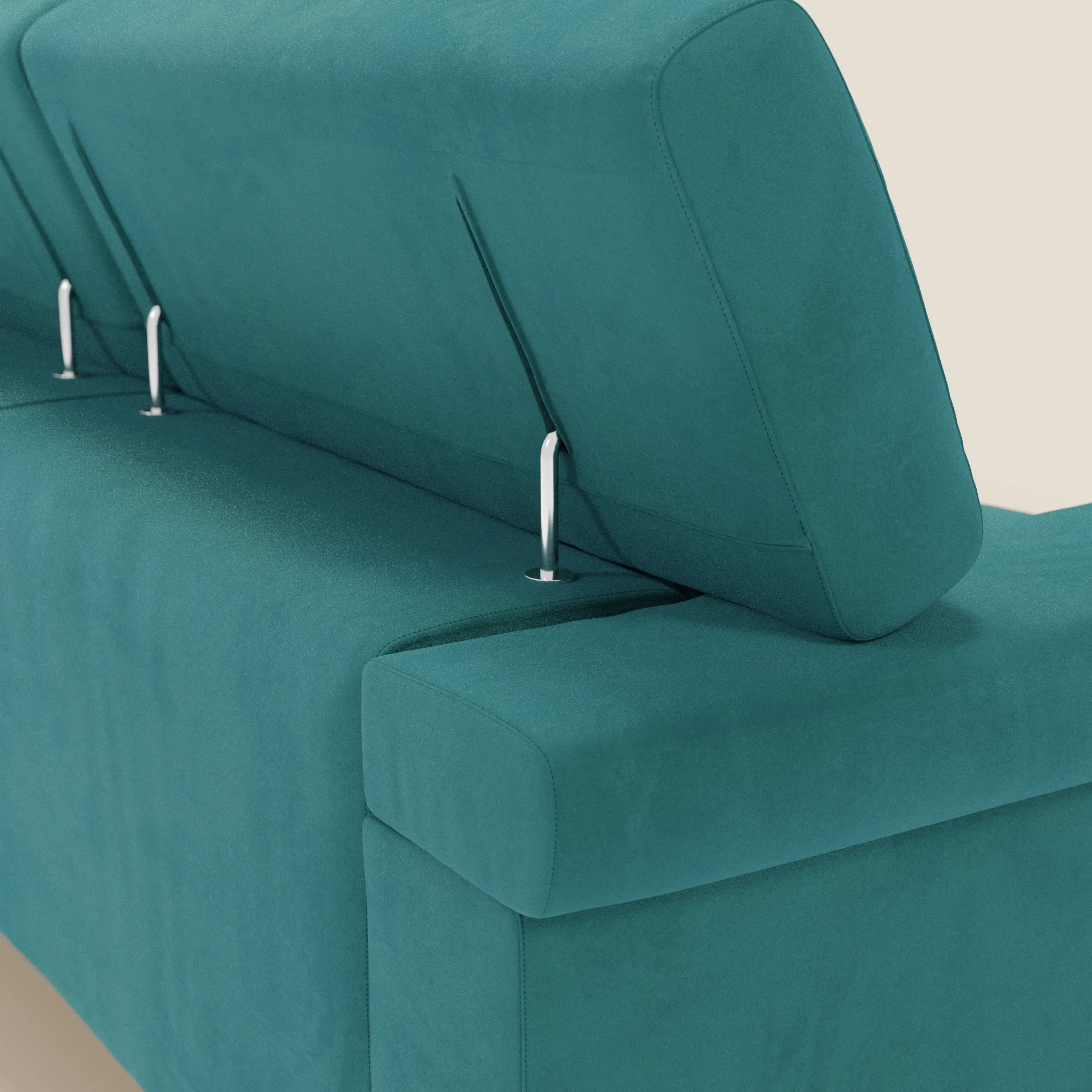 Primo piano del divano angolare Raffaello di Divani.Store in T11 petrolio microfibra smacchiabile, con sedute scorrevoli, poggiatesta regolabili e tre aste metalliche sui cuscini dello schienale, su sfondo beige chiaro.