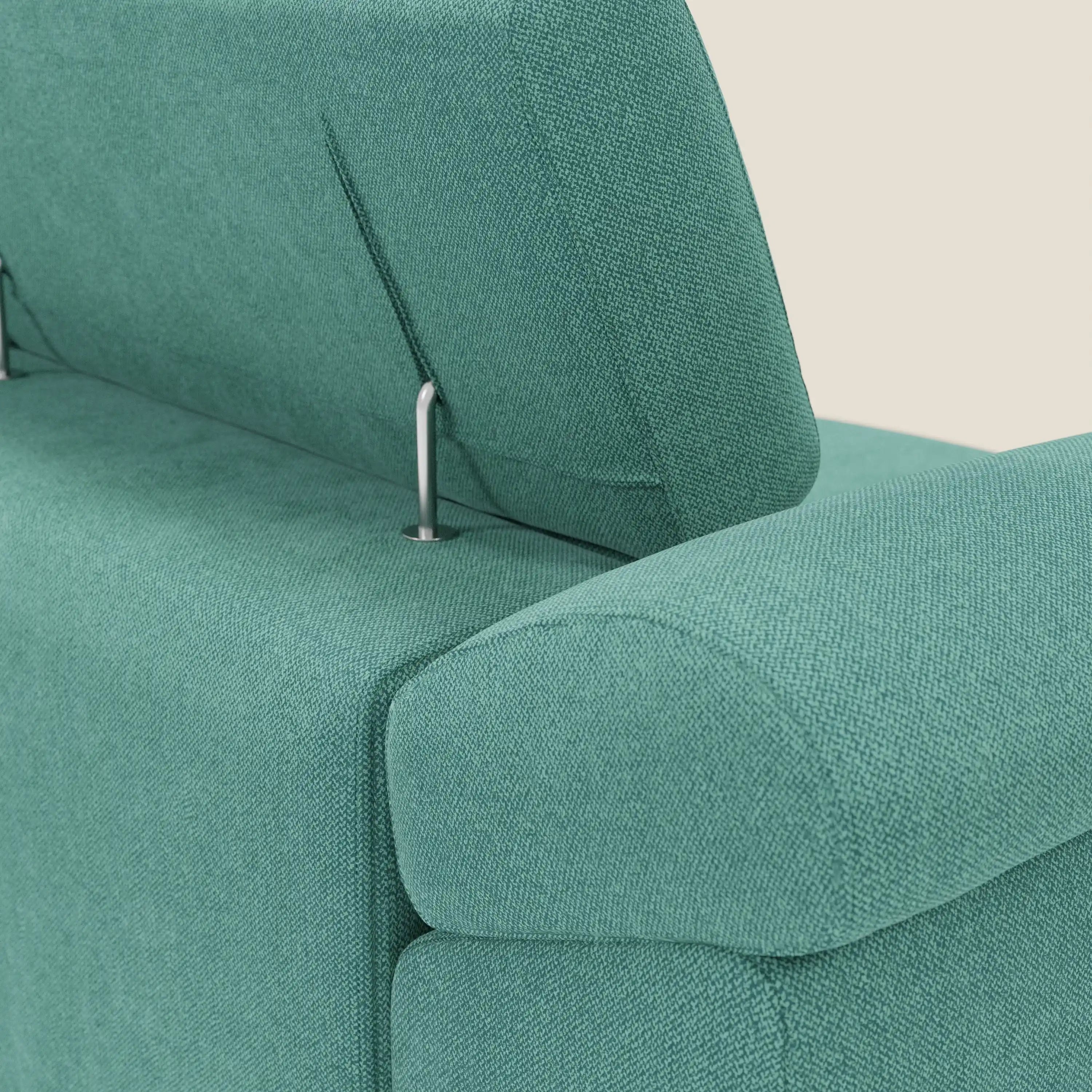 Primo piano del divano Donatello con 3 sedute allungabili di Divani.Store, in tessuto smacchiabile T23 verde acqua, dotato di poggiatesta regolabile con supporto metallico e braccioli contenitore, presentato con un elegante intreccio a trama.