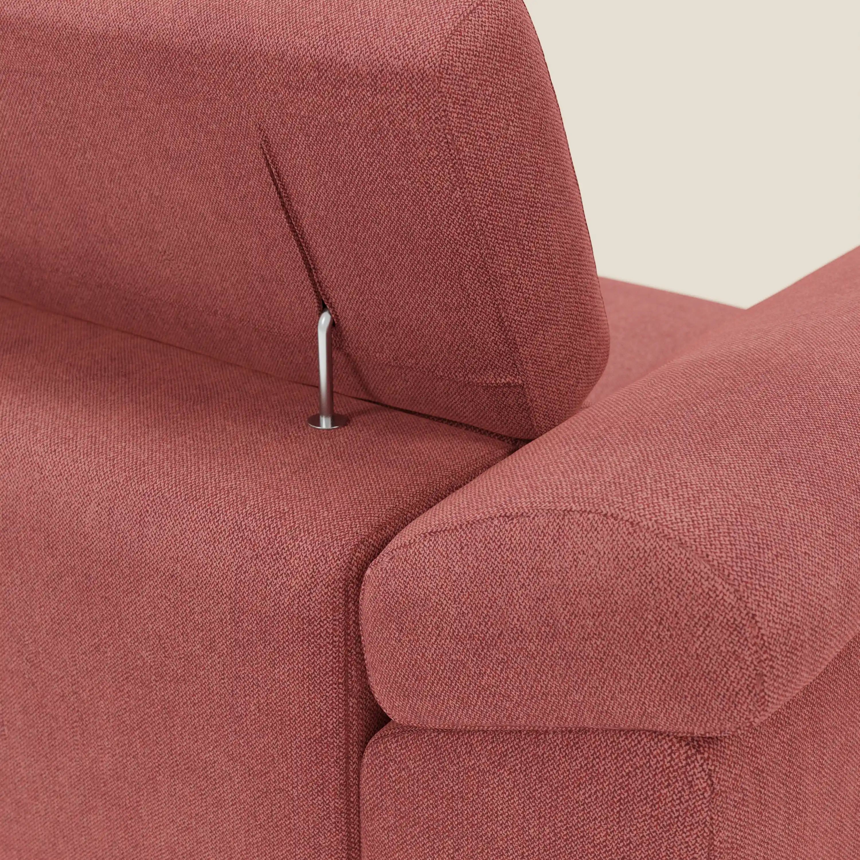 Un primo piano del Donatello Divano angolare con sedute scorrevoli di Divani.Store in tessuto morbido smacchiabile T23 rosso ciliegia mette in evidenza il poggiatesta regolabile, il sottile supporto in metallo e il rivestimento testurizzato su uno sfondo chiaro.